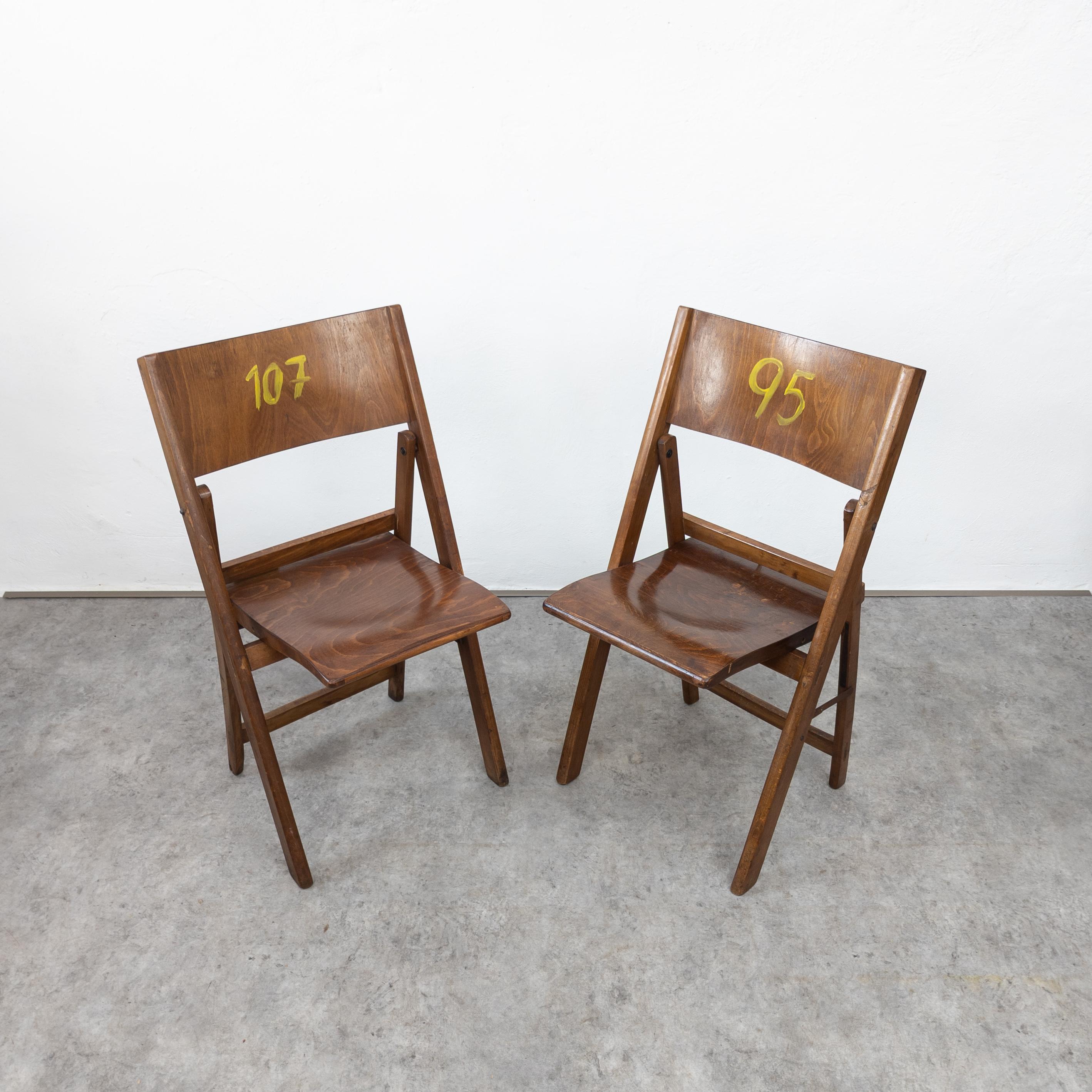 Rare and appealing pair of folding chairs originally from an outdoor cinema are perfect for any modern space. Crafted by Thonet in the 1930s, these chairs remain in good original condition, showcasing a beautiful patina. They are structurally sound,