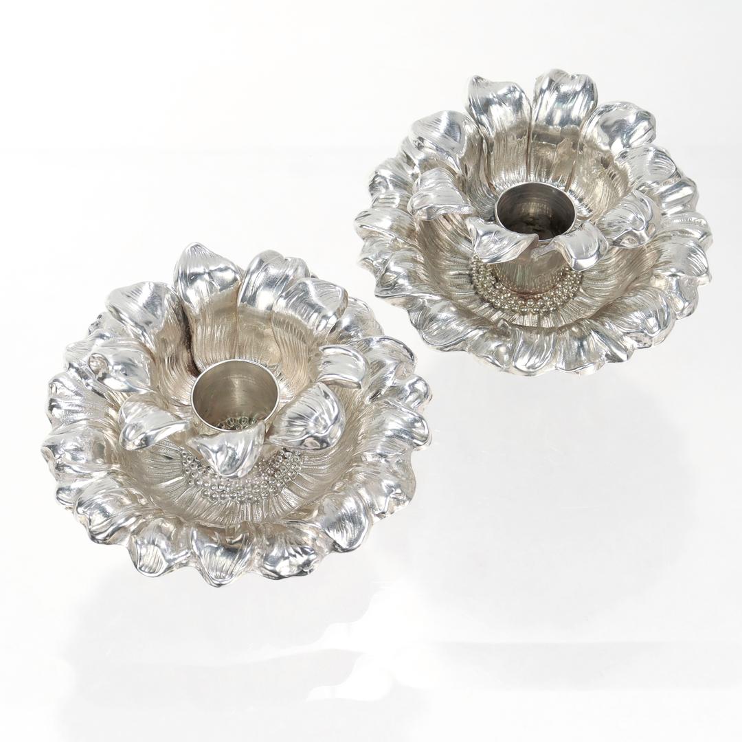 Une belle paire de chandeliers en argent sterling.

Par Tiffany & Co.

Chacune est en forme de tournesol avec un travail de repoussage détaillé.

Ce motif figurait dans l'un des catalogues Tiffany de 1986.

Marqué à la base de chaque pièce pour