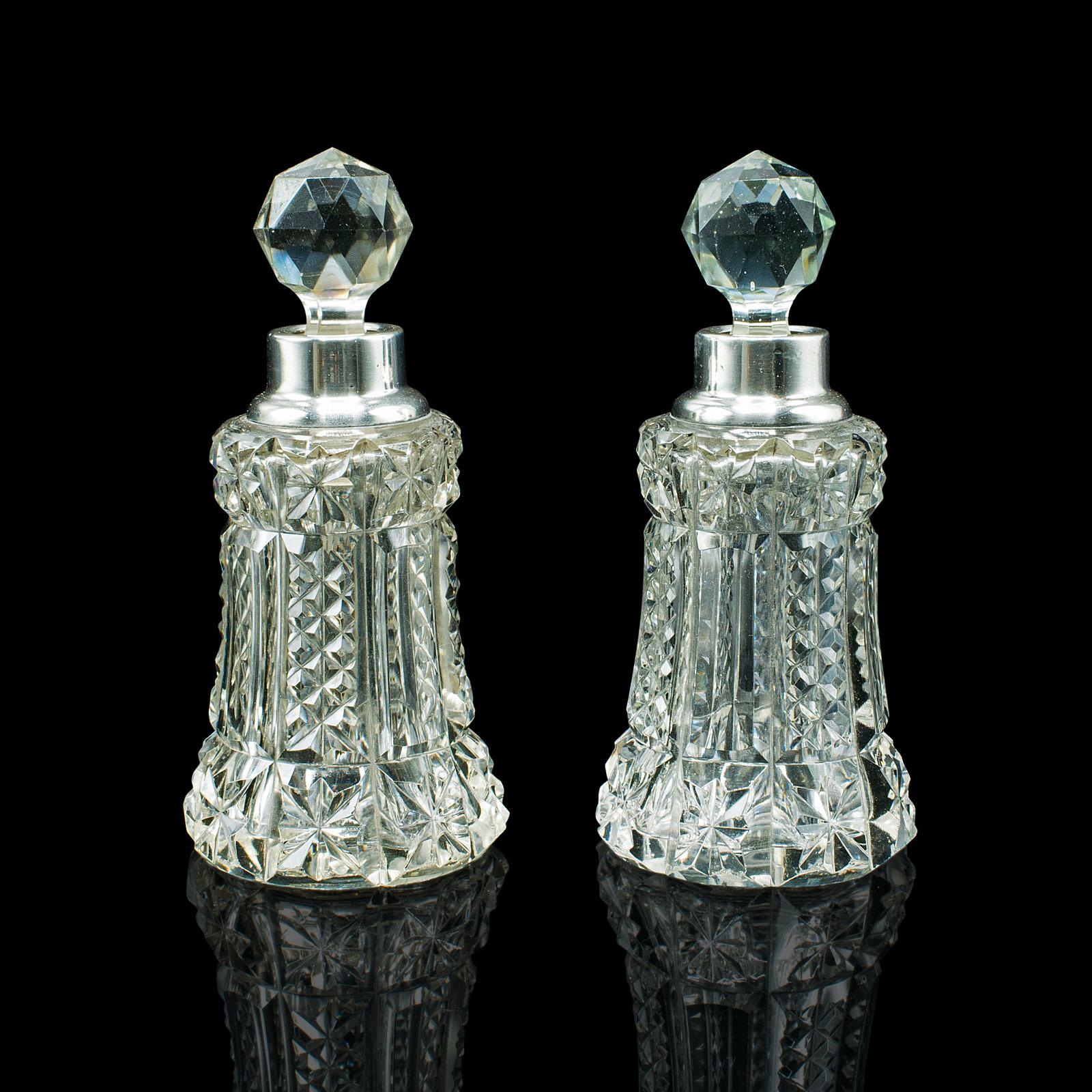 This is a pair of vintage tipple decanters. An English, glass and silver collared small spirit vessel, hallmarked to the early 20th century, dated 1928.

Of petite form, perfect for a quick tipple in the lounge
Displaying a desirable aged patina