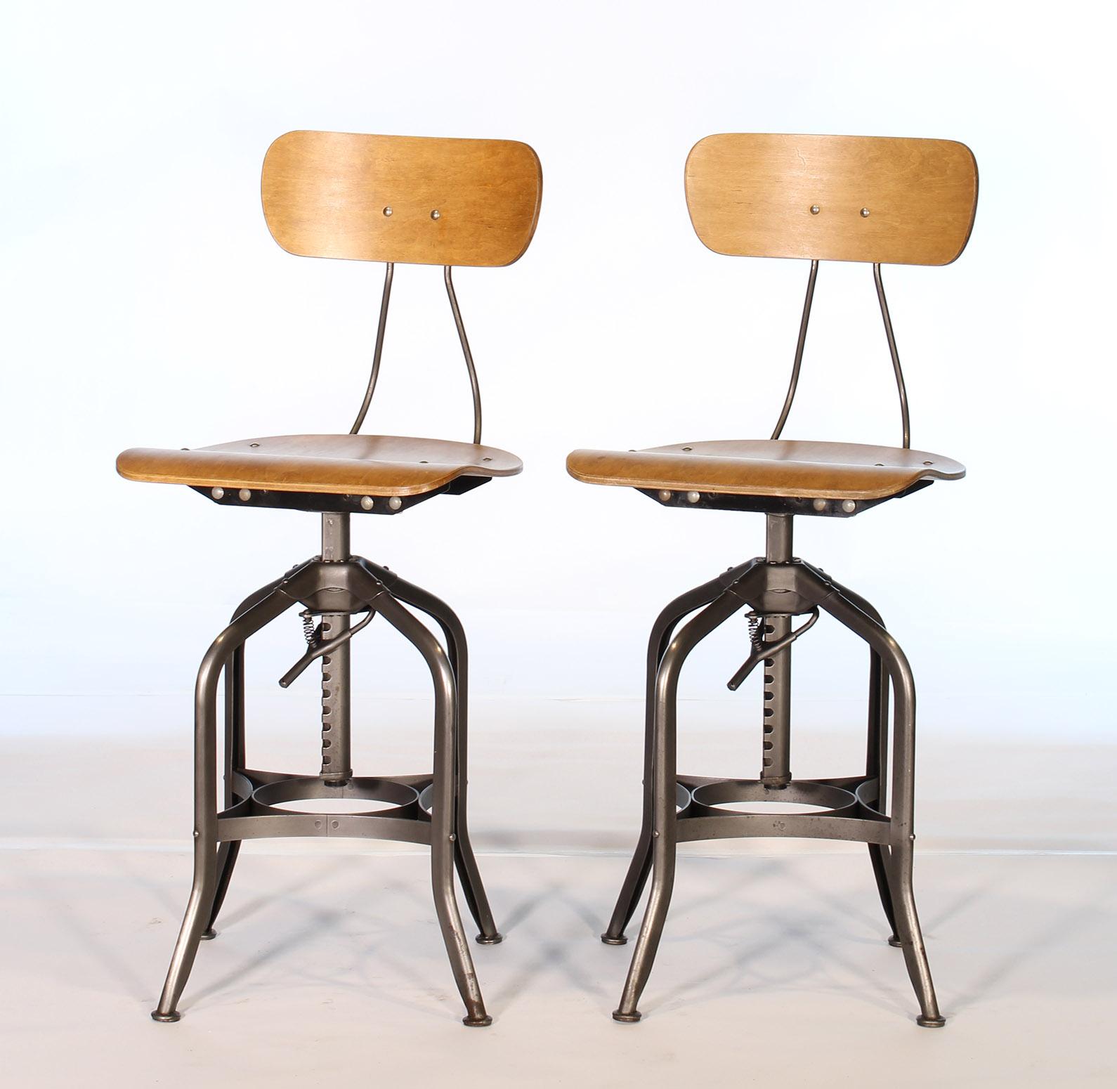 Pair of authentic vintage industrial bent plywood adjustable stools made by Toledo. Stools have been completely taken apart, cleaned, reassembled and checked throughout. A great choice for bar stools or kitchen counter seating. Seat height is