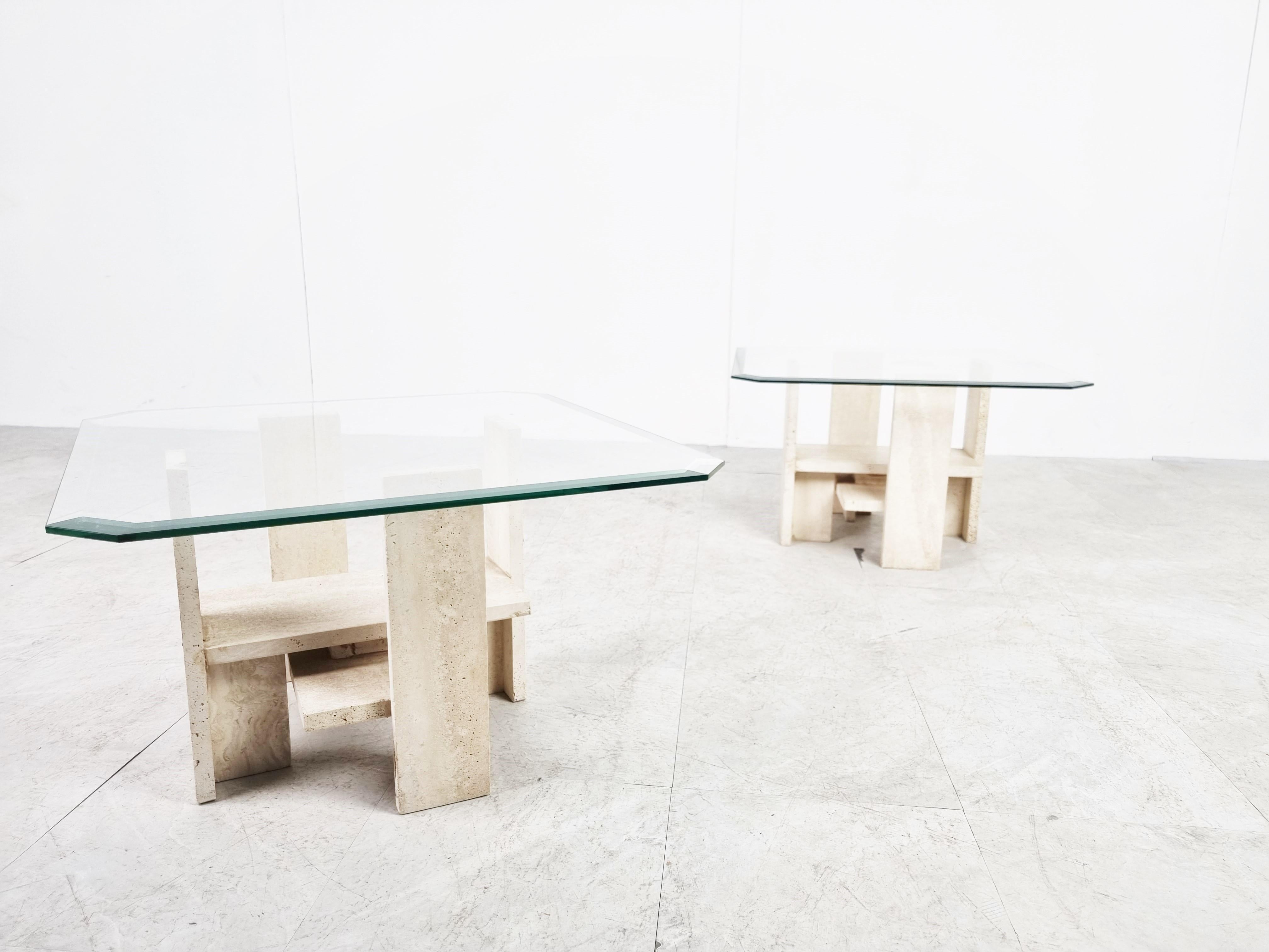 Pair of architectural coffee tables or side tables made from a solid travertine base and with a beveled glass top.

The tables where designed by Willy Ballez.

The modern look/design mixes well with nowadays interiors, especially with the light