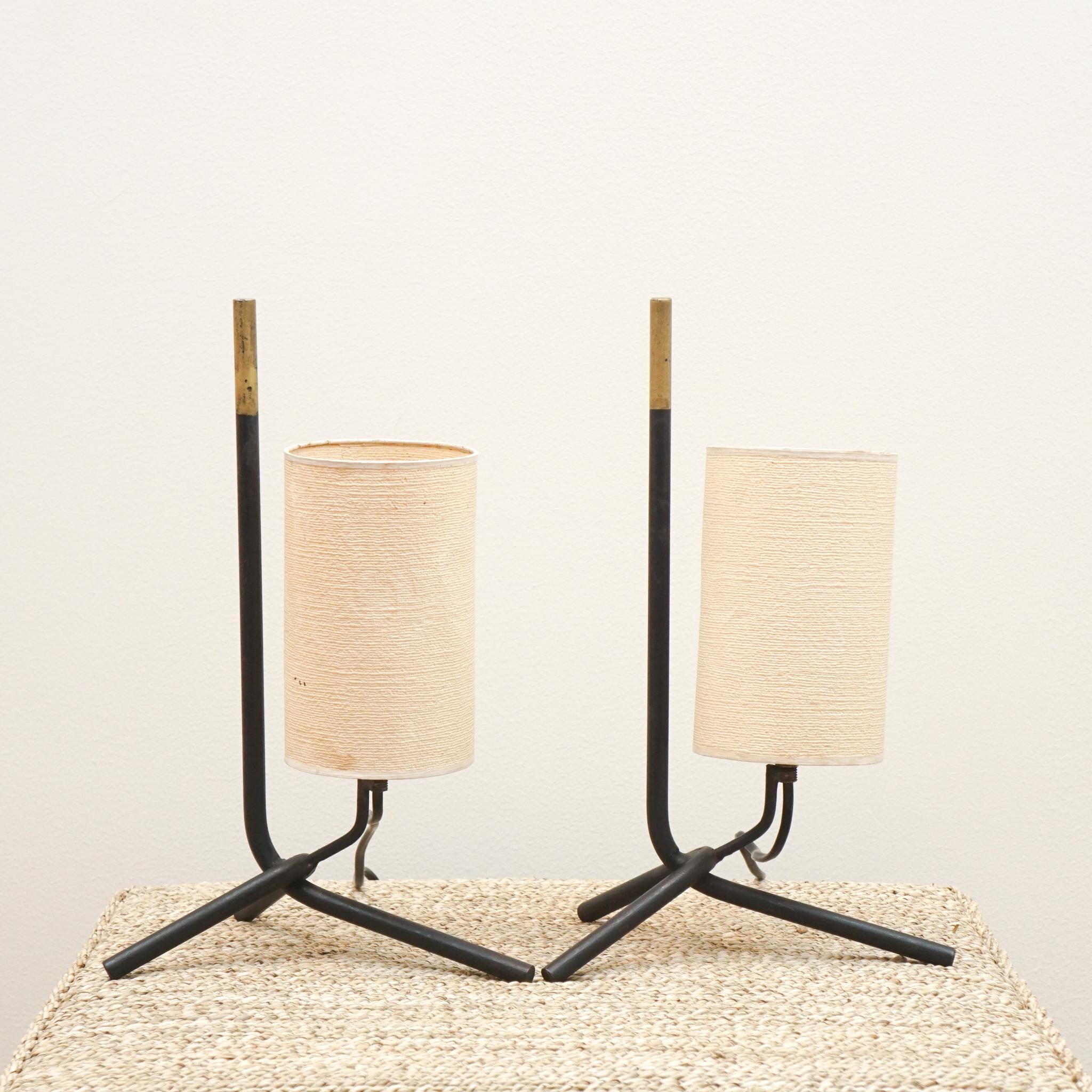 This pair of vintage tripod lamps were sourced in Paris and still have their original shades. Their diminutive size and angular metal stands make them perfect for bedside use. Gold painted detail. Rewired for US.