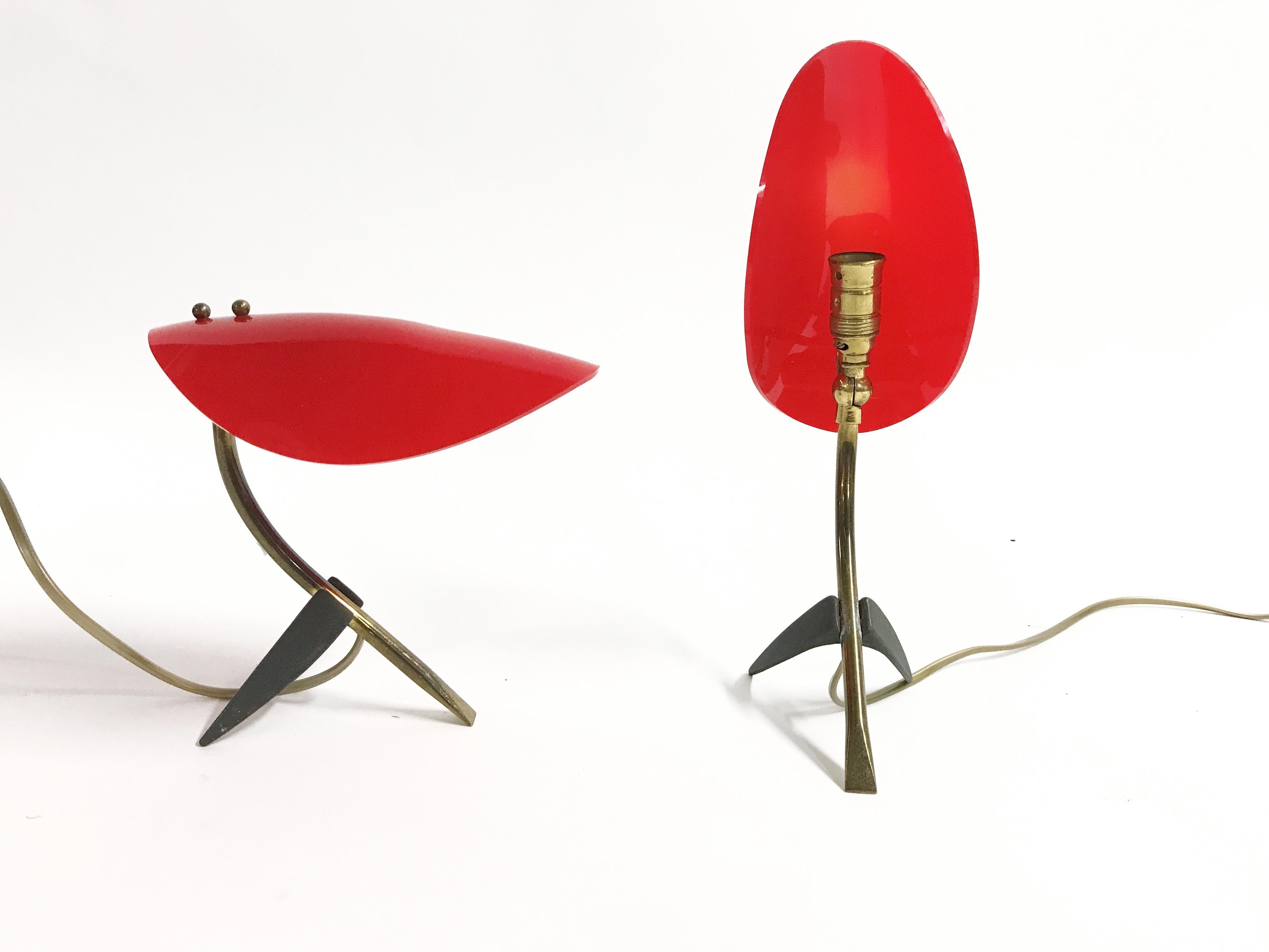 Wonderful pair of italian tripod base table lamps.

The lamps have a brass and black metal base with a red plastic adjustable shade.

Rewired with the original brass bulb holder, tested and ready for use.

The lamps take E14 light