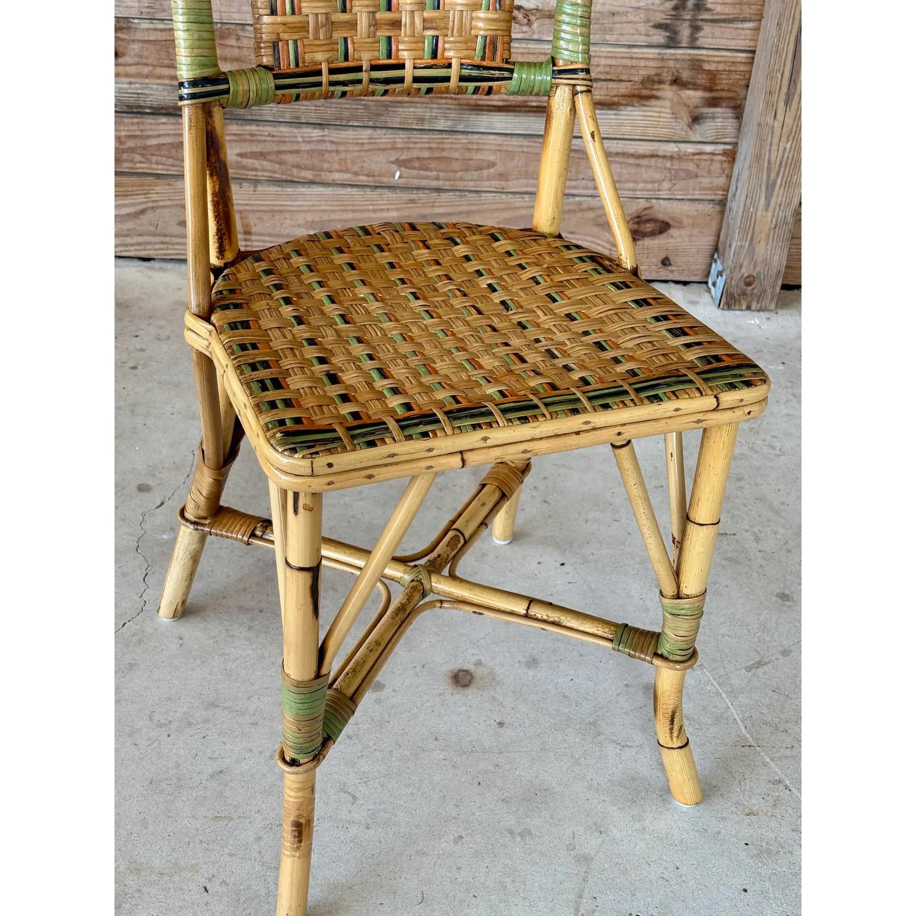 Charming Mid-20th Century rattan bistro side chair featuring colorful woven accents and a sculptural bow detail at the top. A light refinishing has been completed to preserve the original finish while protecting its coastal character.
Chair shows