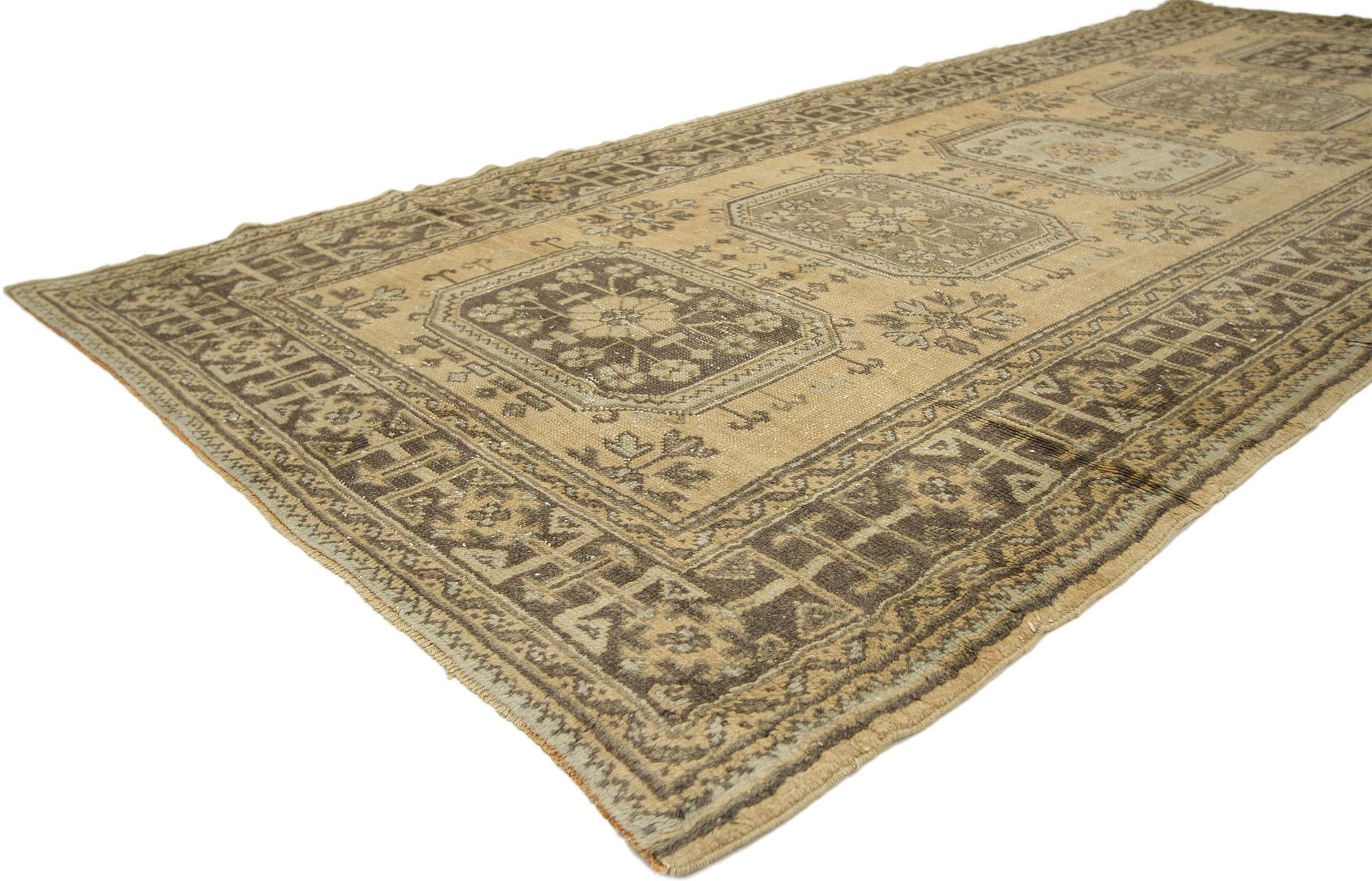51144 Vintage Turkish Oushak Hallway runner 05'00 x 11'09. This hand-knotted wool vintage Turkish Oushak runner features five amulet medallions filled with roundels and floral sprays floating on an abrashed ecru field dotted with complementary