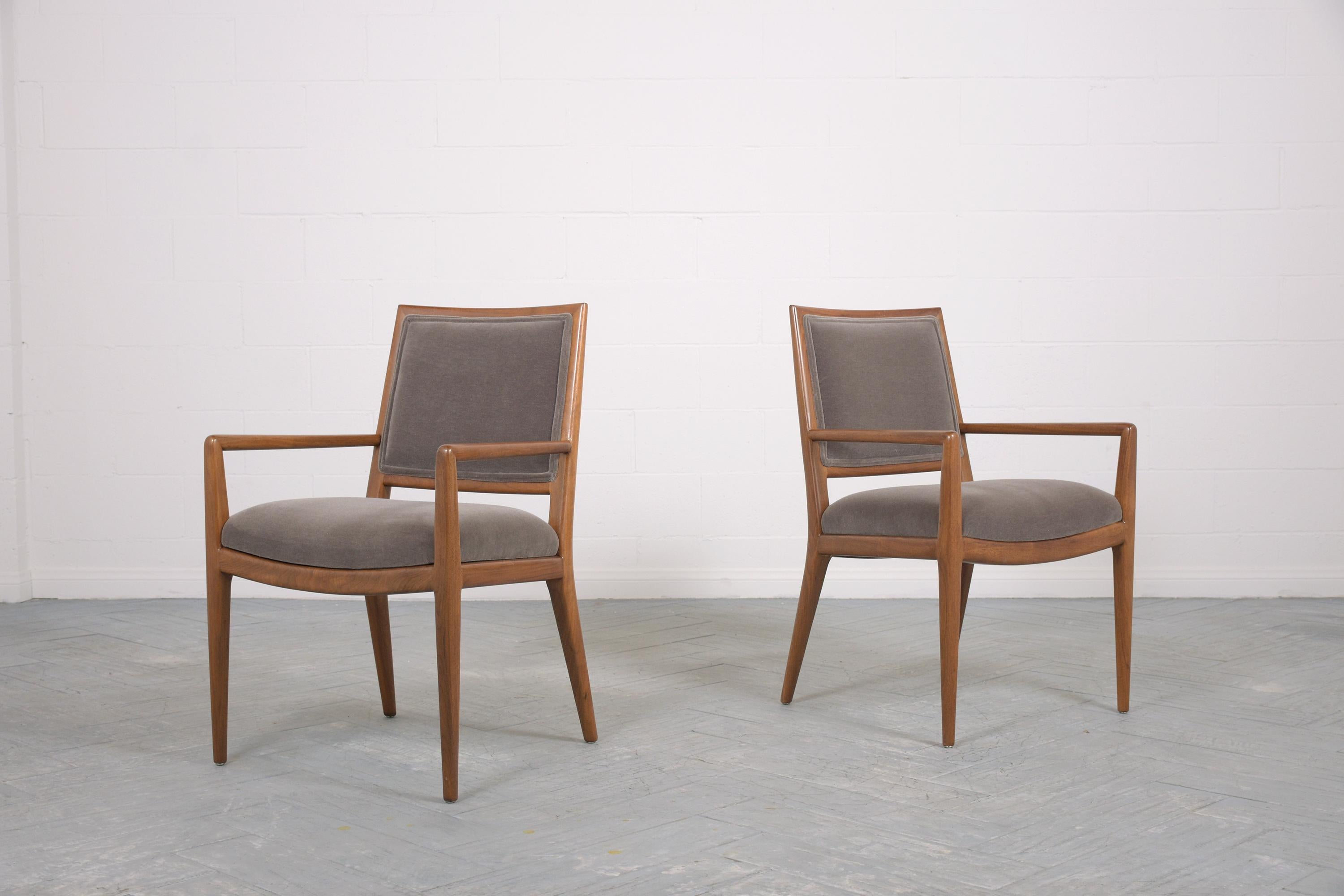 Introducing a remarkable pair of vintage mid-century modern armchairs, reminiscent of the iconic Robsjohn Gibbings style from the 1960s. With a legacy steeped in design brilliance, these chairs, masterfully handcrafted from premium walnut wood, have