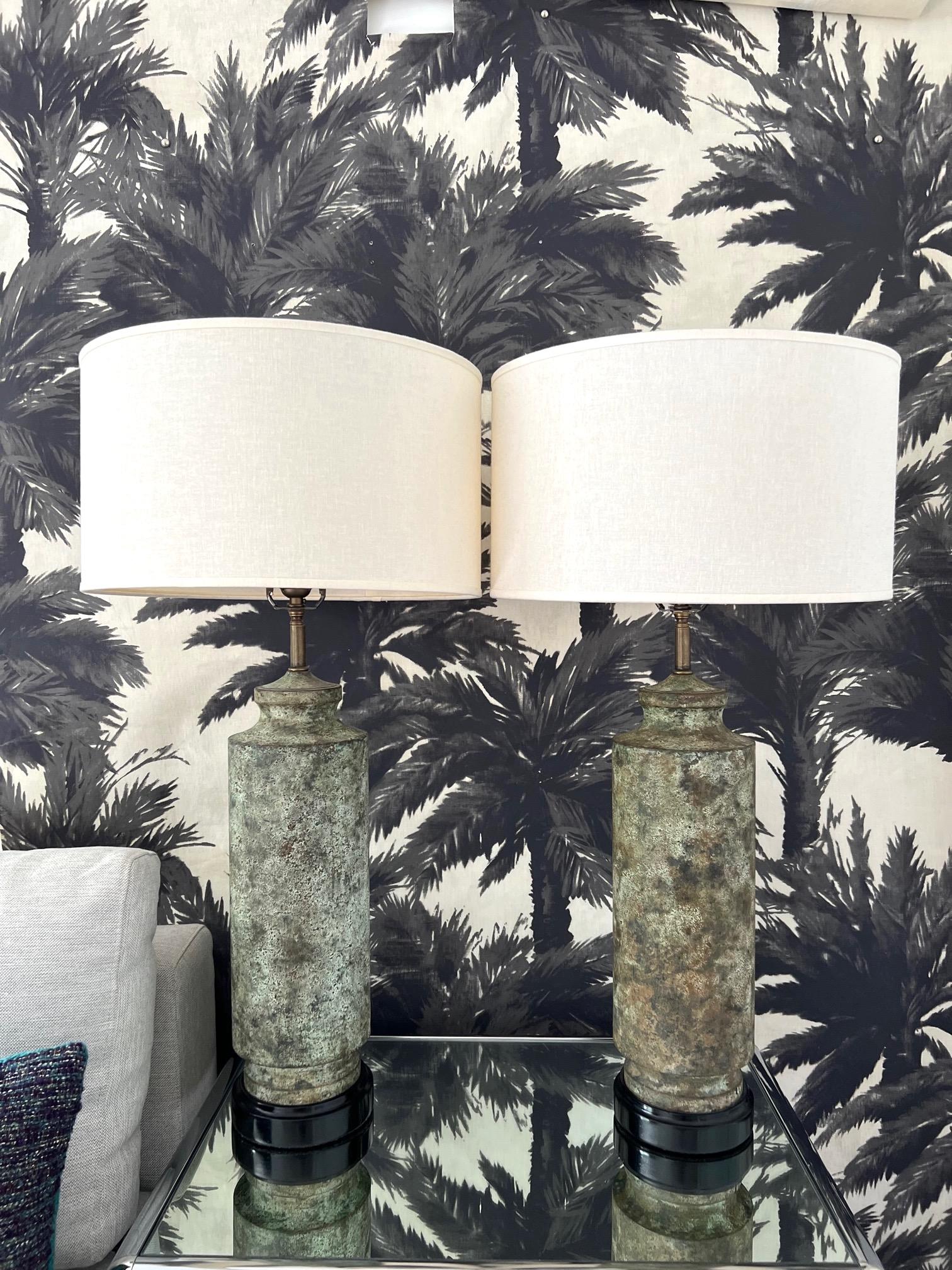 Pair of Brutalist Mid-Century Modern lamps with Verdigris patina. Made of cast iron, the column lamps have tapered bases and feature stylized pagoda tops. The metal has been purposely oxidized for a distressed, patina look reminiscent of camouflage