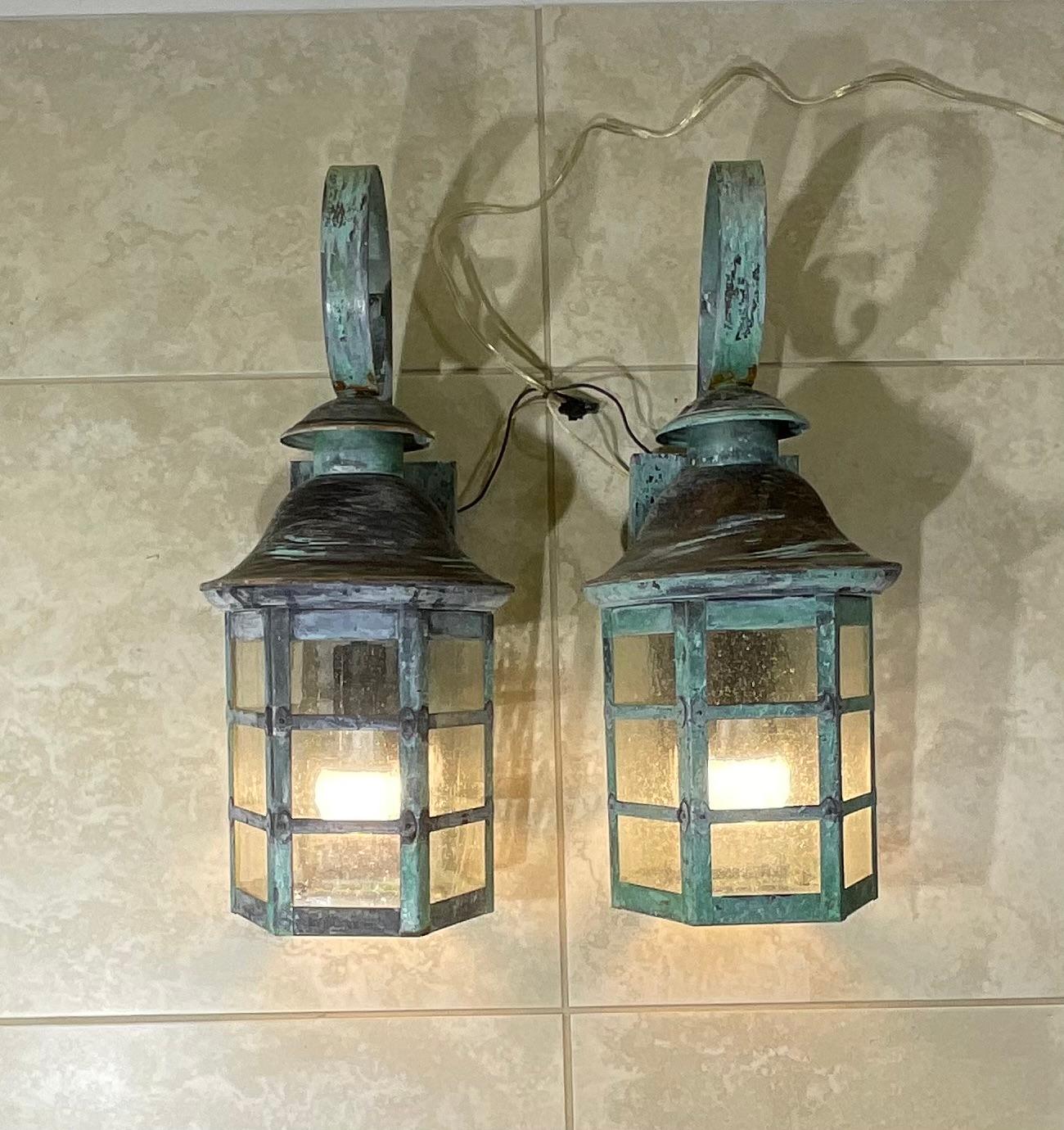 Elegant pair of wall hanging lantern hand forged with solid brass and copper beautiful patina, seeded glass. Electrified with one 60/watt light each, suitable for wet locations.
Great decorative pair of lantern.