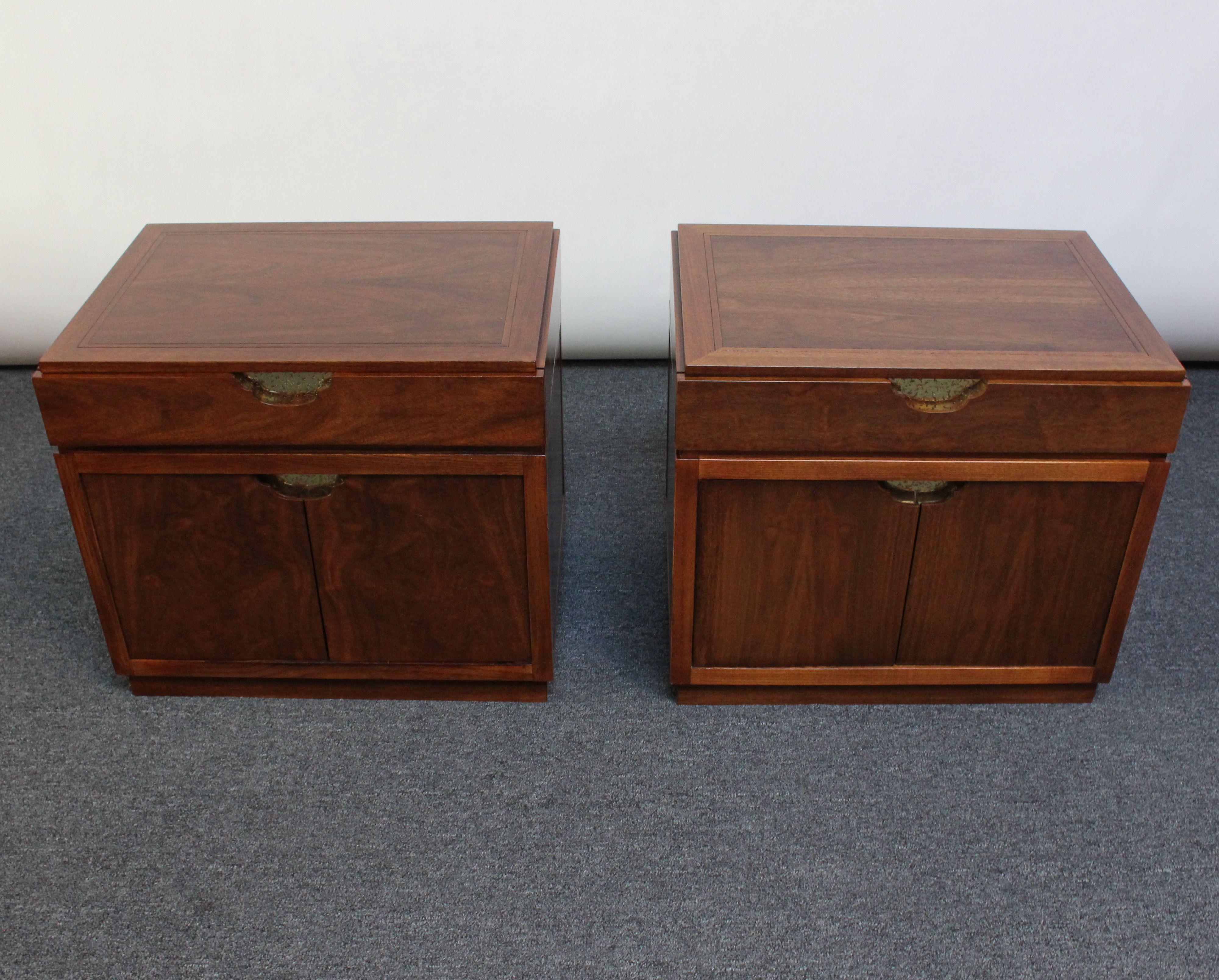 Elegant and scarce pair of Baker black walnut nightstands with recessed, hammered and etched brass drawer-pulls (ca. 1980,USA).
Dual doors concealing open storage on the bottom and a shallow drawer on top.
Exquisite wood grain with vertical