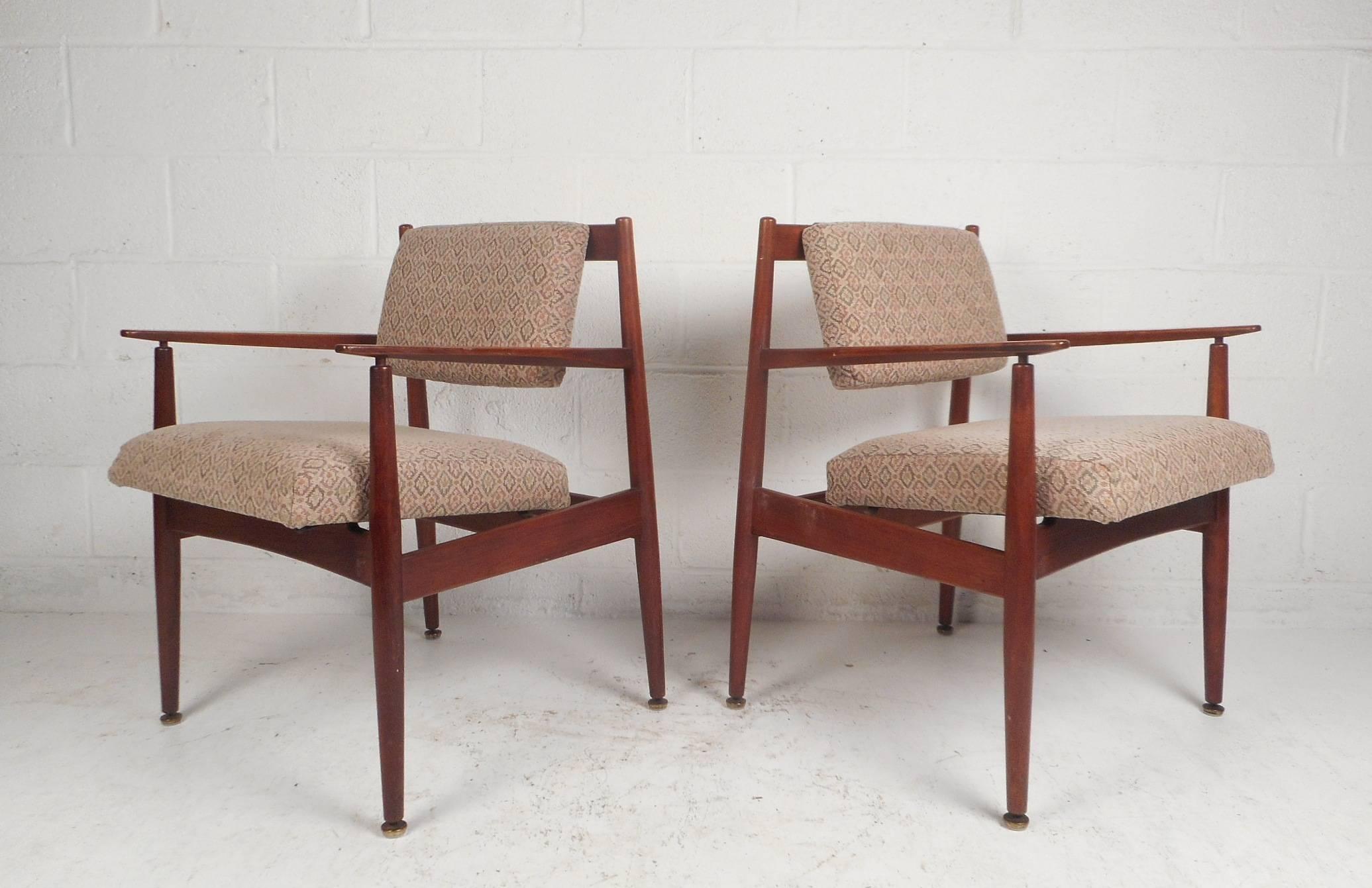 This stunning pair of Mid-Century Modern arm chairs by Jens Risom Design feature extremely thick padded seating, a floating style backrest, and sculpted arm rests. A sturdy walnut frame and lovely decorative upholstery add to the allure. This