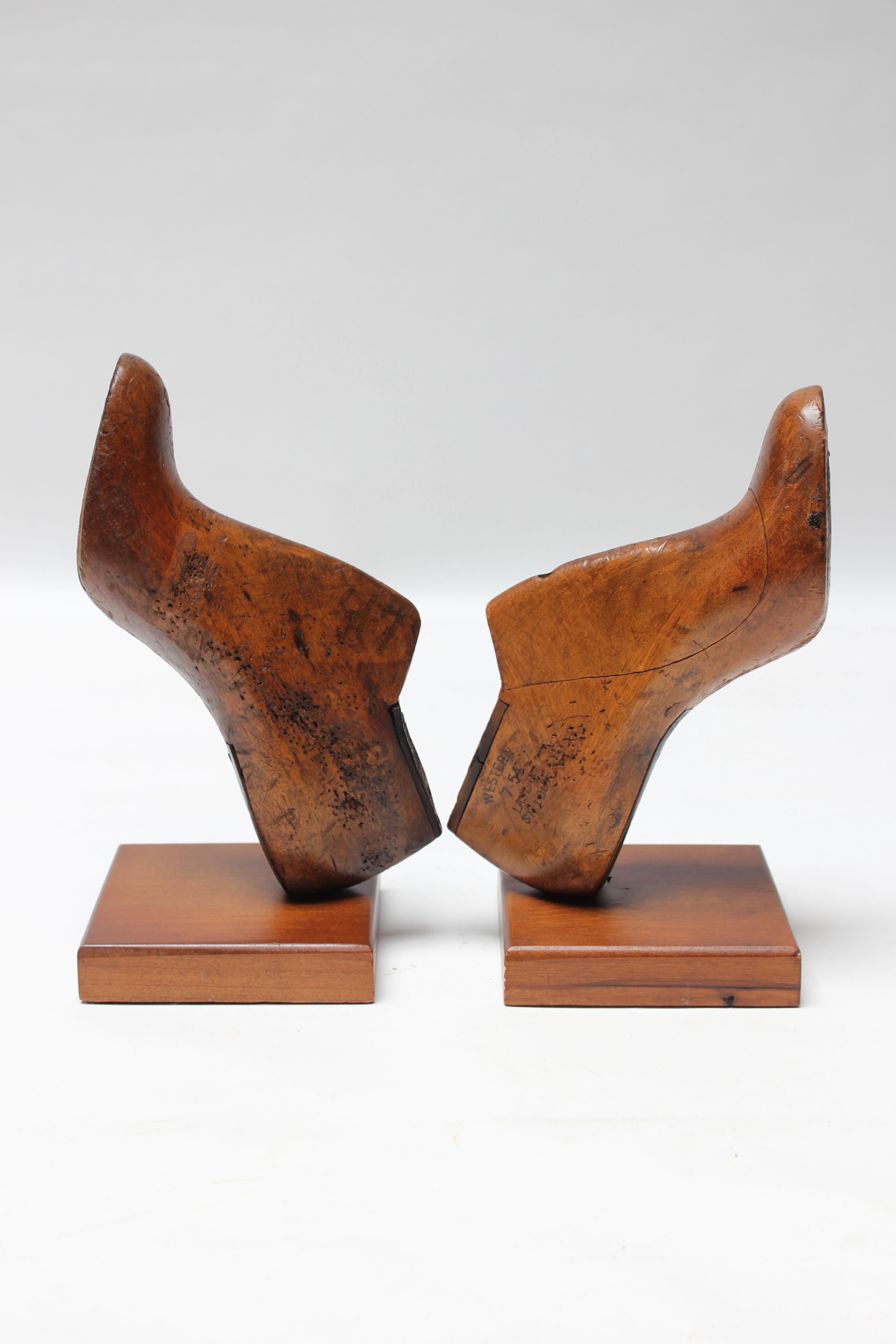 Ein Paar Frauenschuhformen der Größe 6, die zu Buchstützen umfunktioniert wurden (ca. 1930er Jahre, St. Louis, Missouri, USA). Da die Schuhe selbst als Formen für die Herstellung von Schuhen verwendet wurden, sind neben der natürlich gealterten