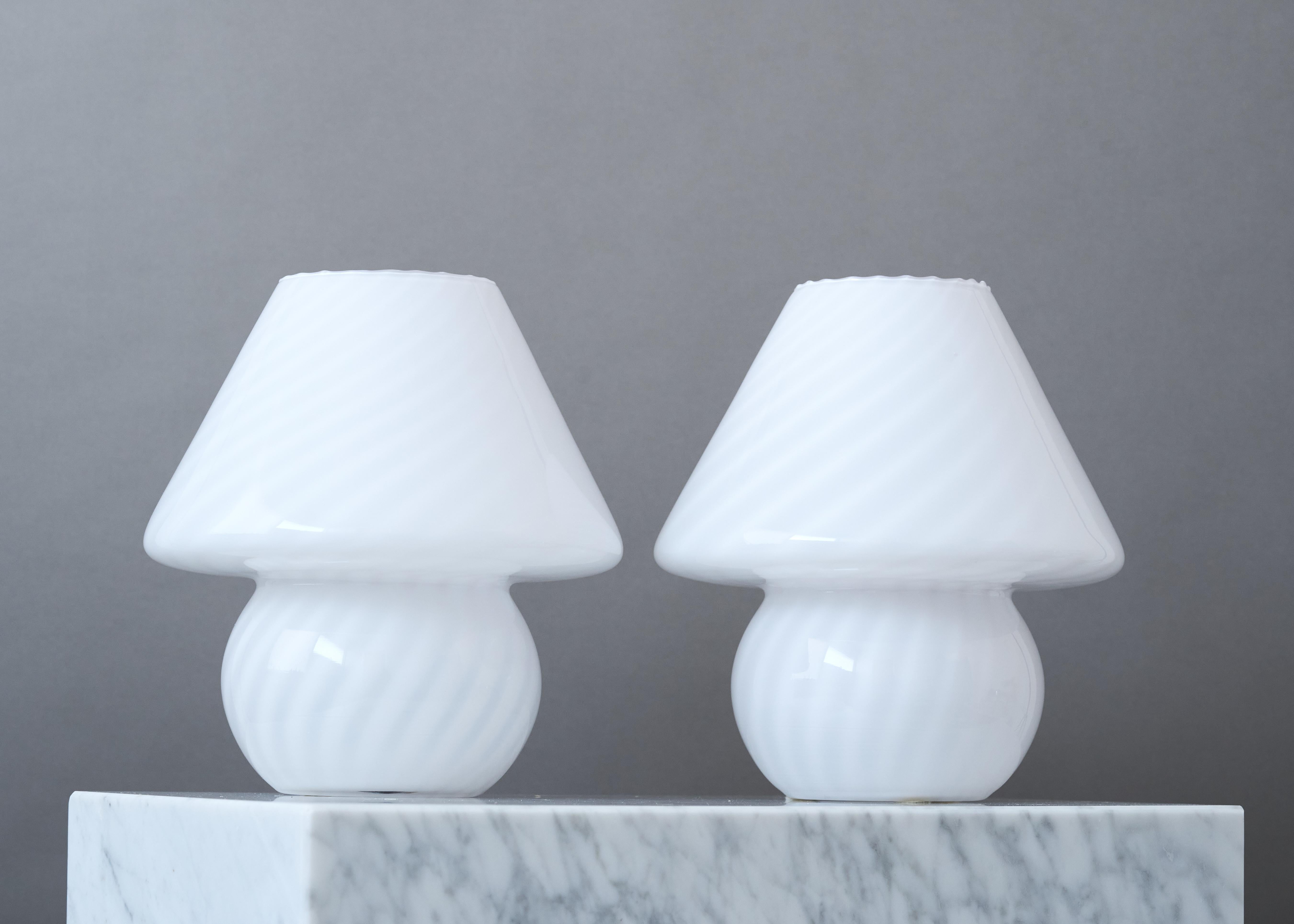 Pareja de lámparas de sobremesa vintage de cristal blanco en forma de seta.
Fabricado en Murano. Italia, años 70.

Gran estado original. 

Fuente de luz: Bombilla de rosca E26/E27.
Enciende el cable blanco. 

