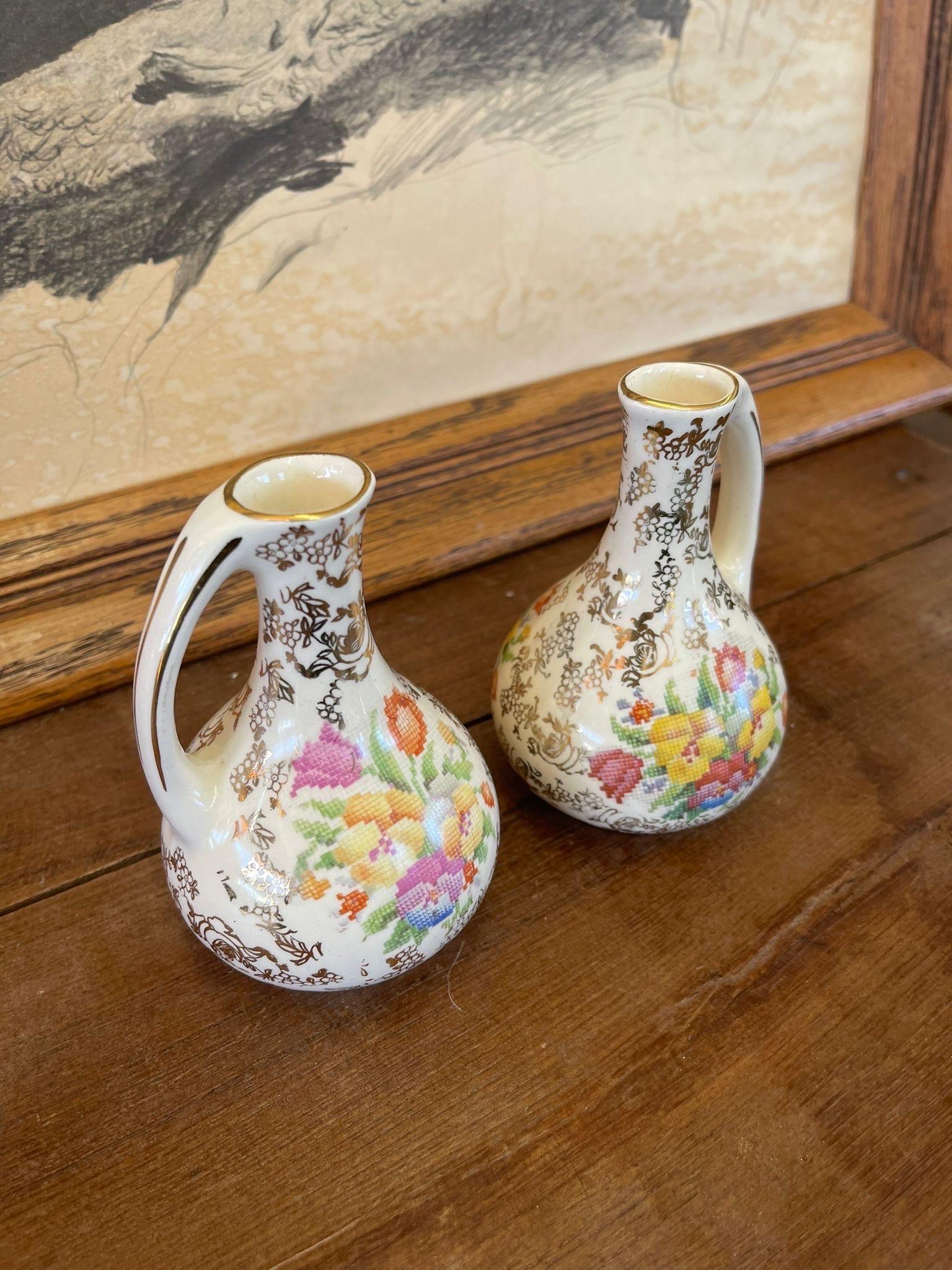 Vases are Covered with Gold Toned Flower Motifs with Central Images of Embroidered Bouquet. Makers Mark on Bottom Stating Made in England as Pictured.

Dimensions. 3 W ; 3 D ; 5 H