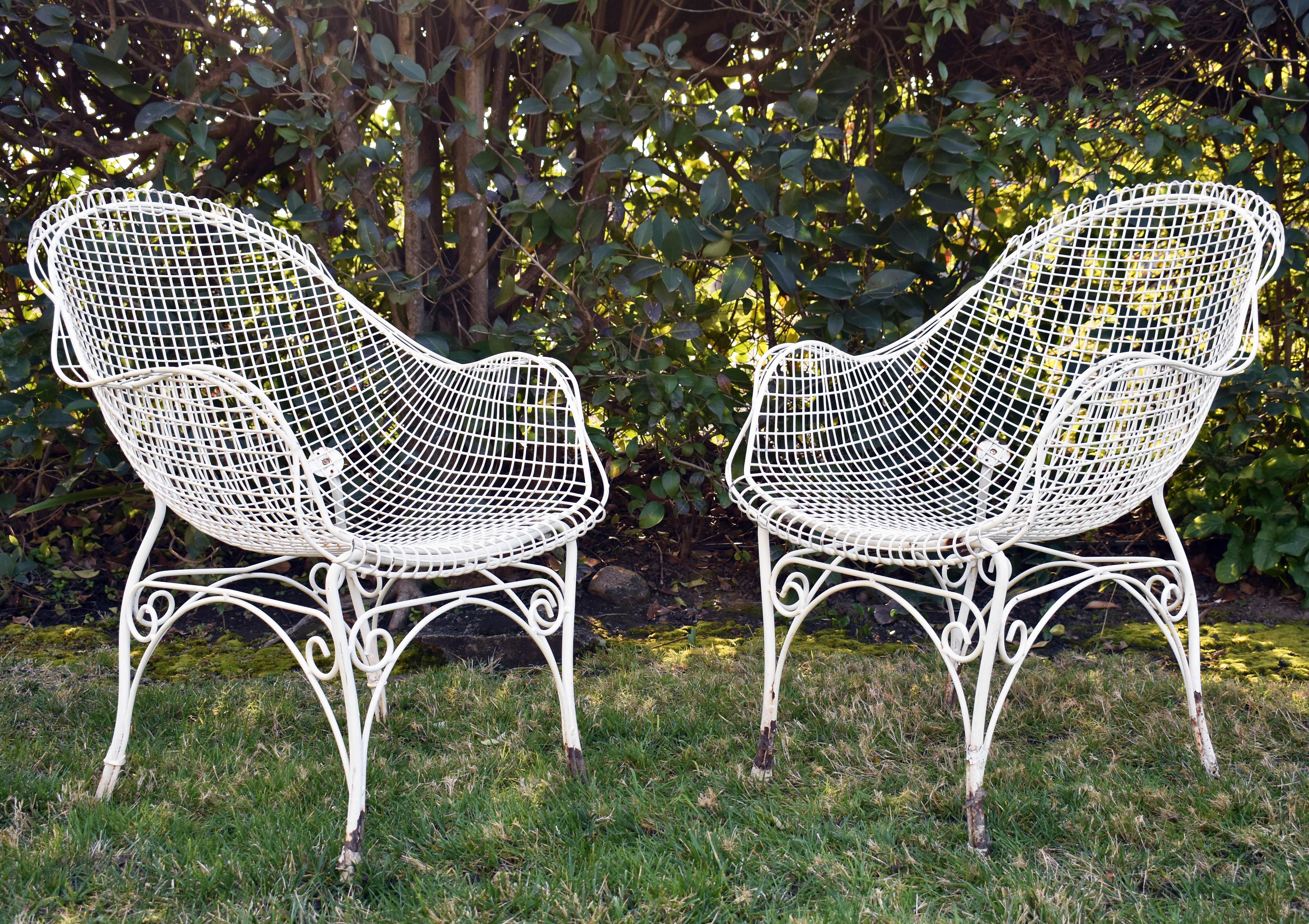 Pair of vintage white wire mesh garden chairs from France, c. 1960s. Volute details on chair bases. 

