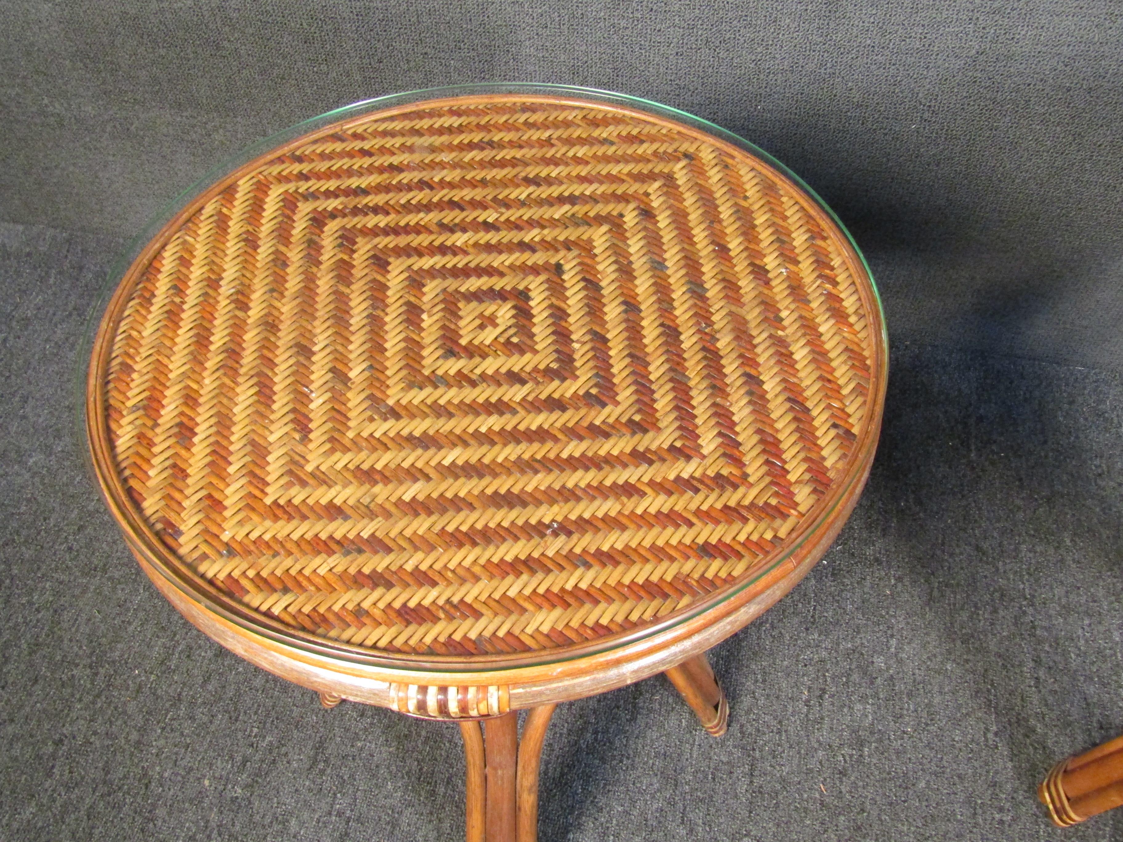 Beautiful pair of vintage wicker side tables with glass tops. Woven wicker creates an impressive geometric pattern on the top that is showcased through the glass. Please confirm item location with seller (NY/NJ).