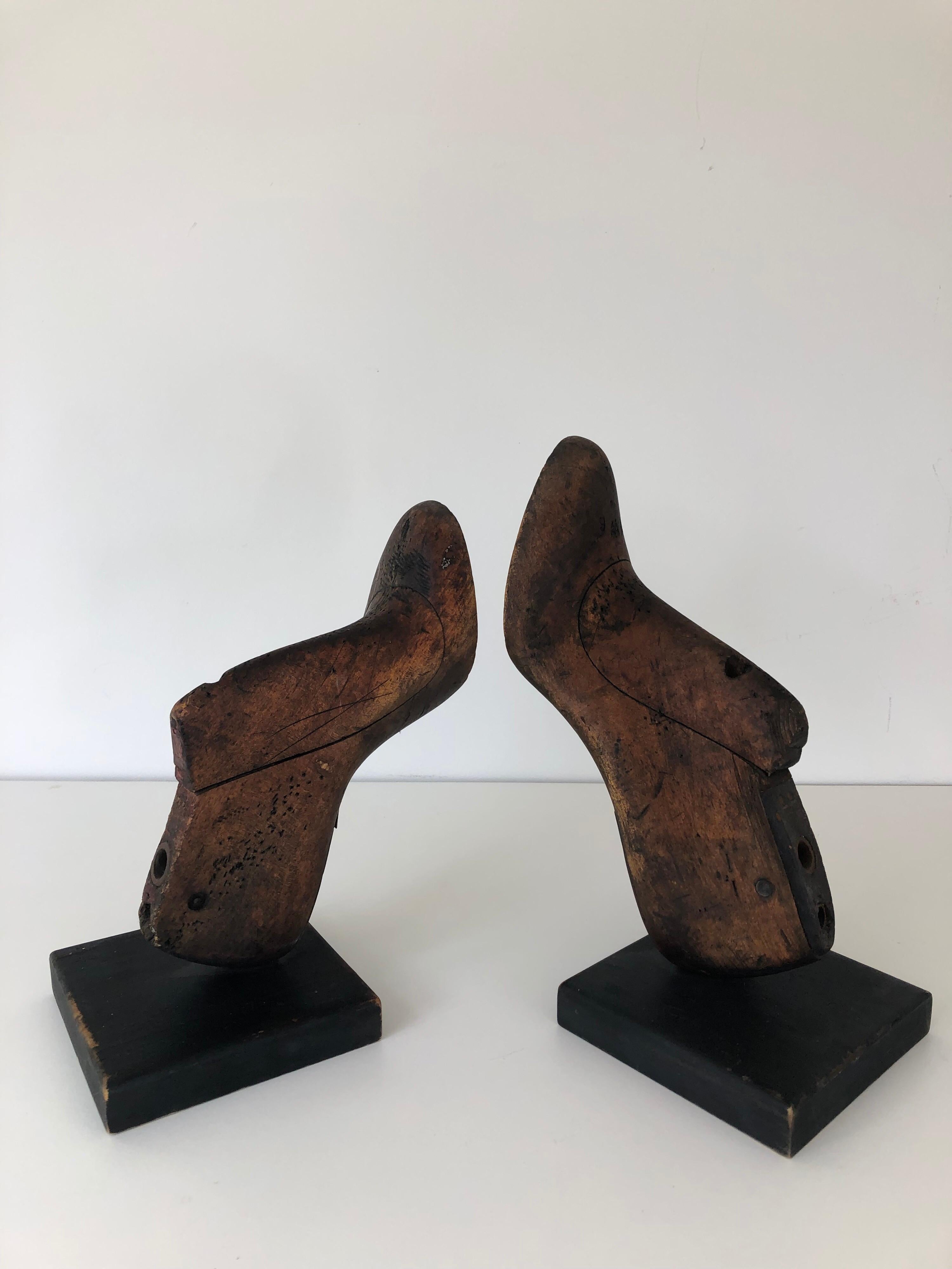 A pair of vintage wood shoe molds, now as bookends. Mounted on black painted base.