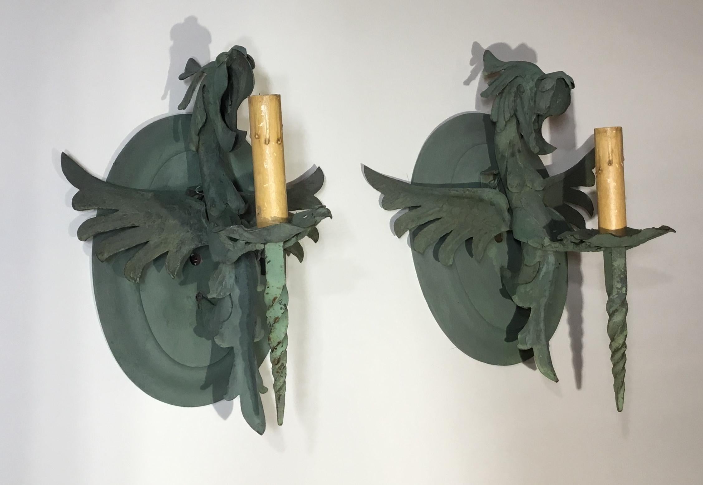 Unusual pair of wall sconces artistically made and forged in the shape of beautiful dragon, wood backplate. This pair was acquired from Miami Beach estate. Electrified with one 60/watt light each, ready to use.