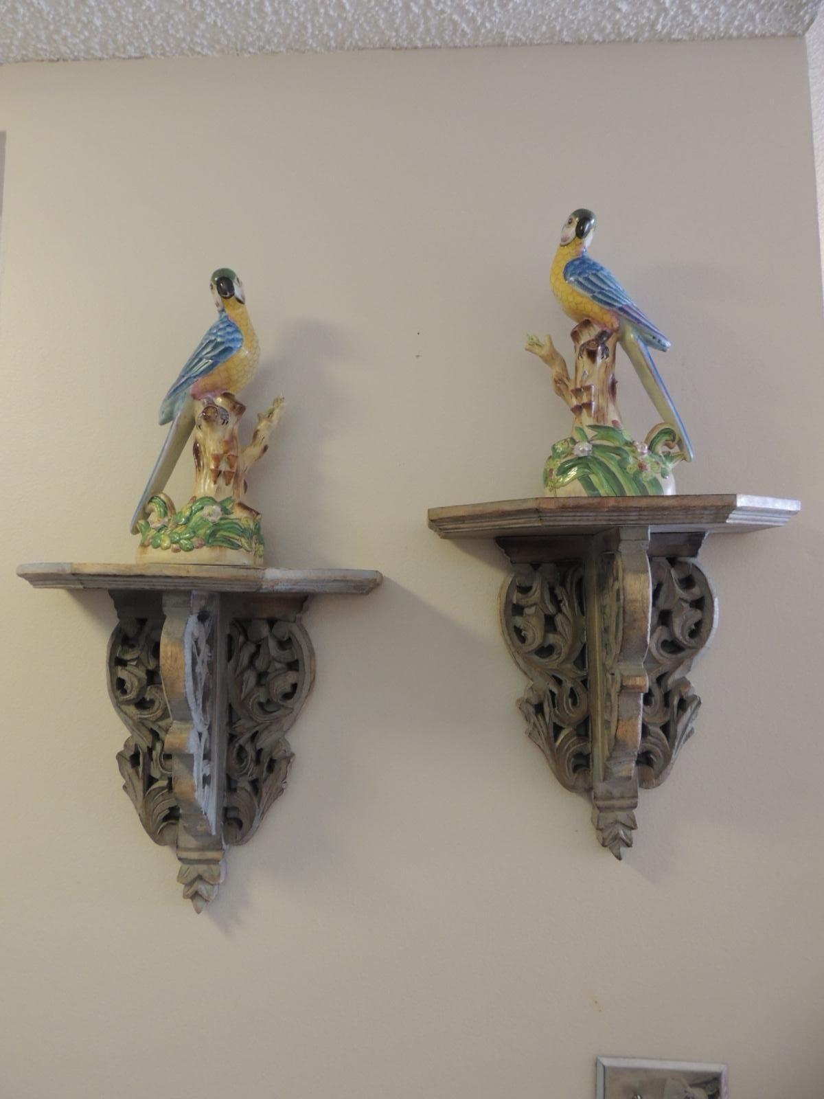 Pair of vintage Chinese Export hand-painted parrots on wood brackets.
Pair of intricate hand-painted detailed ceramic Chinese Export parrots. The flowers, the tree trunks and the birds have a real life feel. In shades of yellow, blue, pink, green,