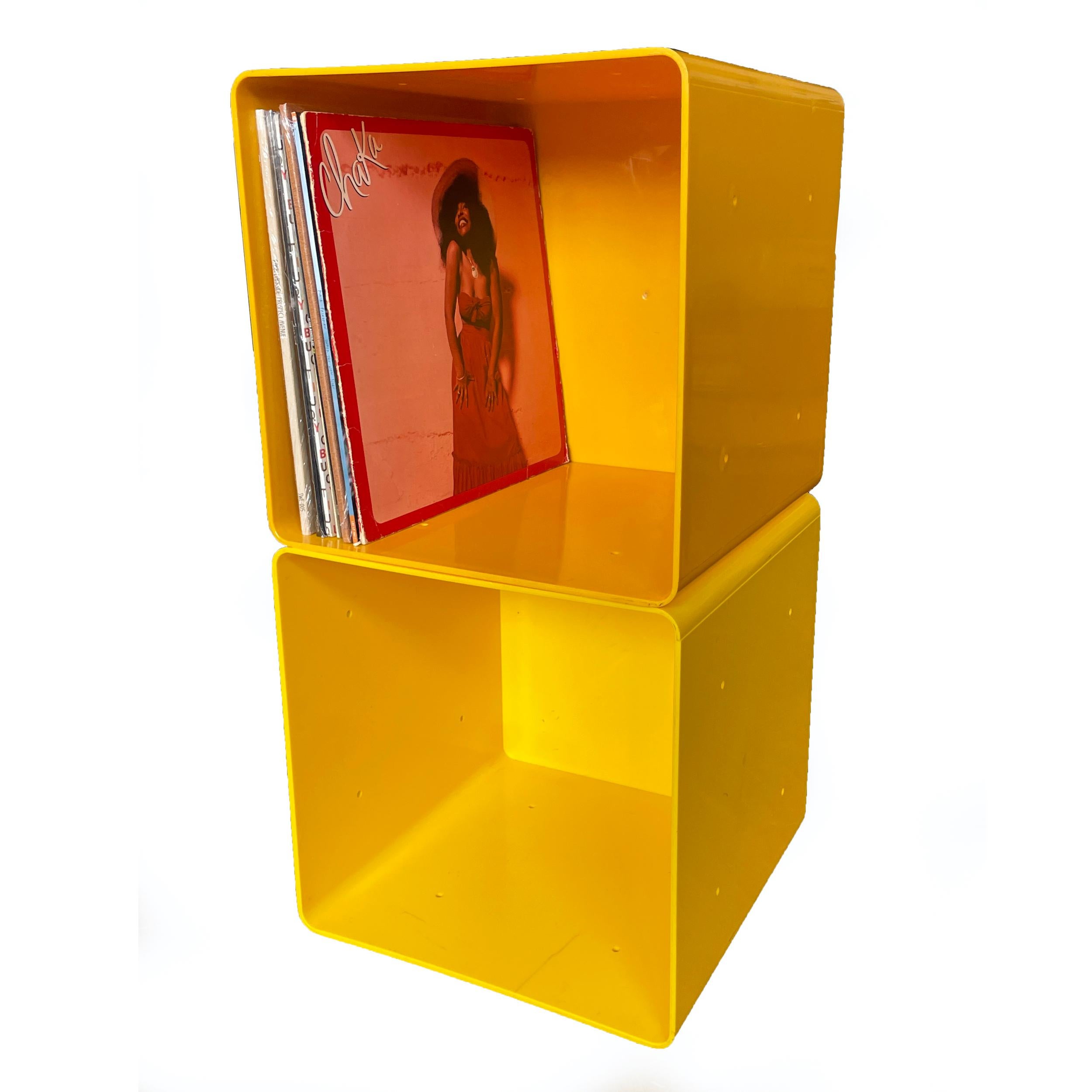 A pair of yellow plastic storage cubes in the style of Kartell or Palaset. Perfectly sized for storing vinyl records but could also be used for books or collectibles. The cubes have 4 small holes on each side so that they can be held together when