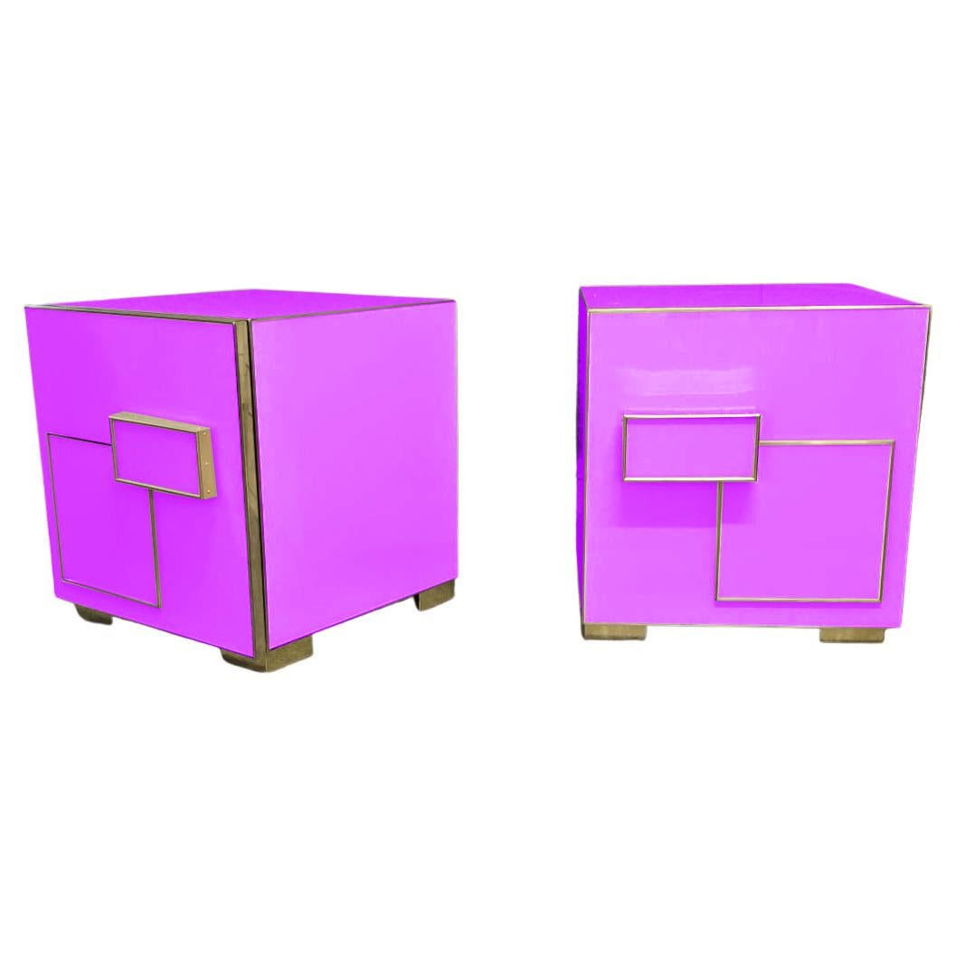 A striking pair of purple Art Deco bedside tables, a bold fusion of glamour and geometric precision.

Finished in purple/fuchsia Murano glass, each piece features elegant lines and a sculptural brass inlay that forms an eye-catching geometric