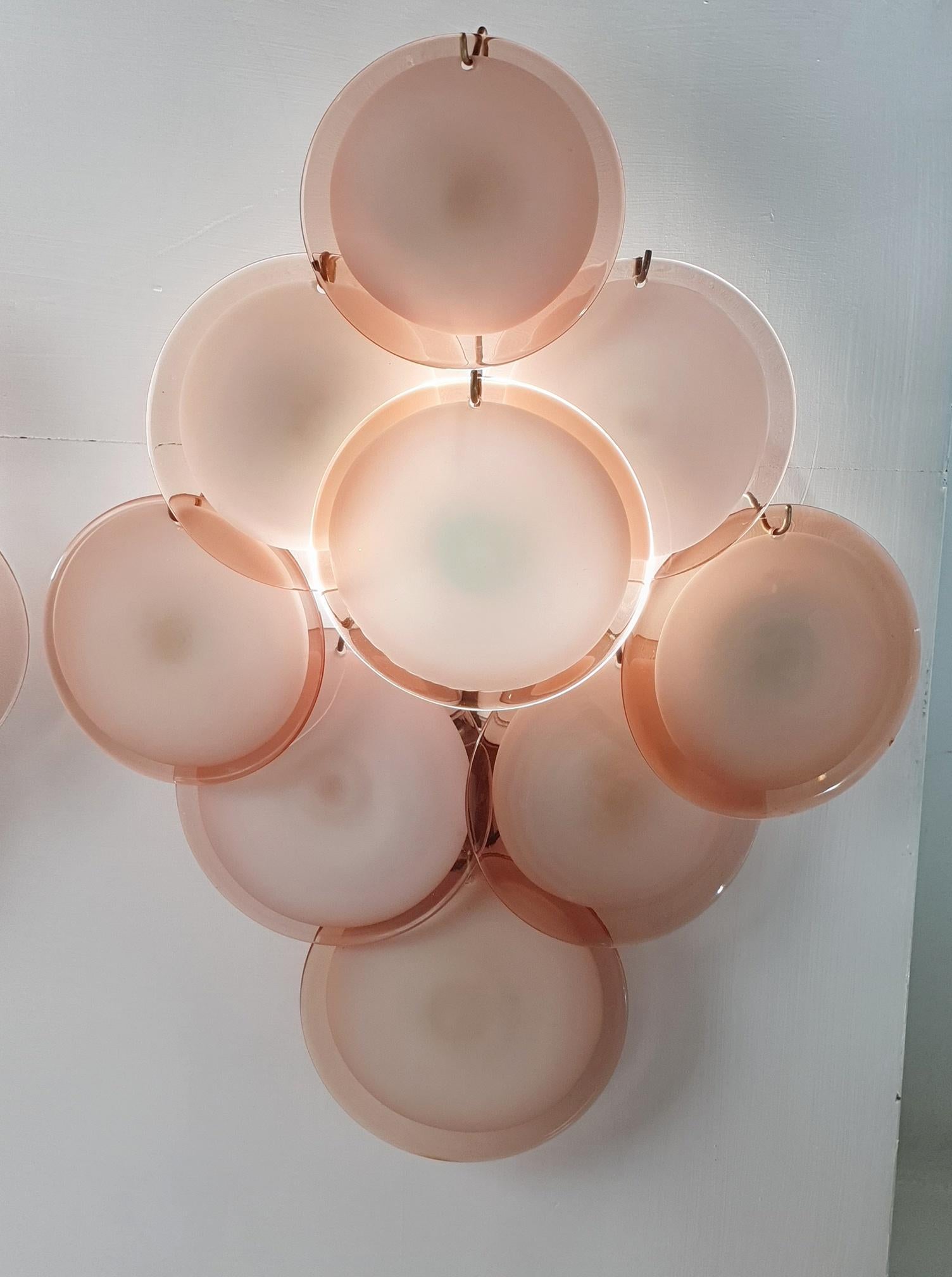 Pair of extra-large wall sconces by Vistosi Murano, in amber/pink tones. The glass discs are handmade with a white opaque centre covered with an amber/pink clear glass. Each sconce nine discs of slightly various size and execution since they are