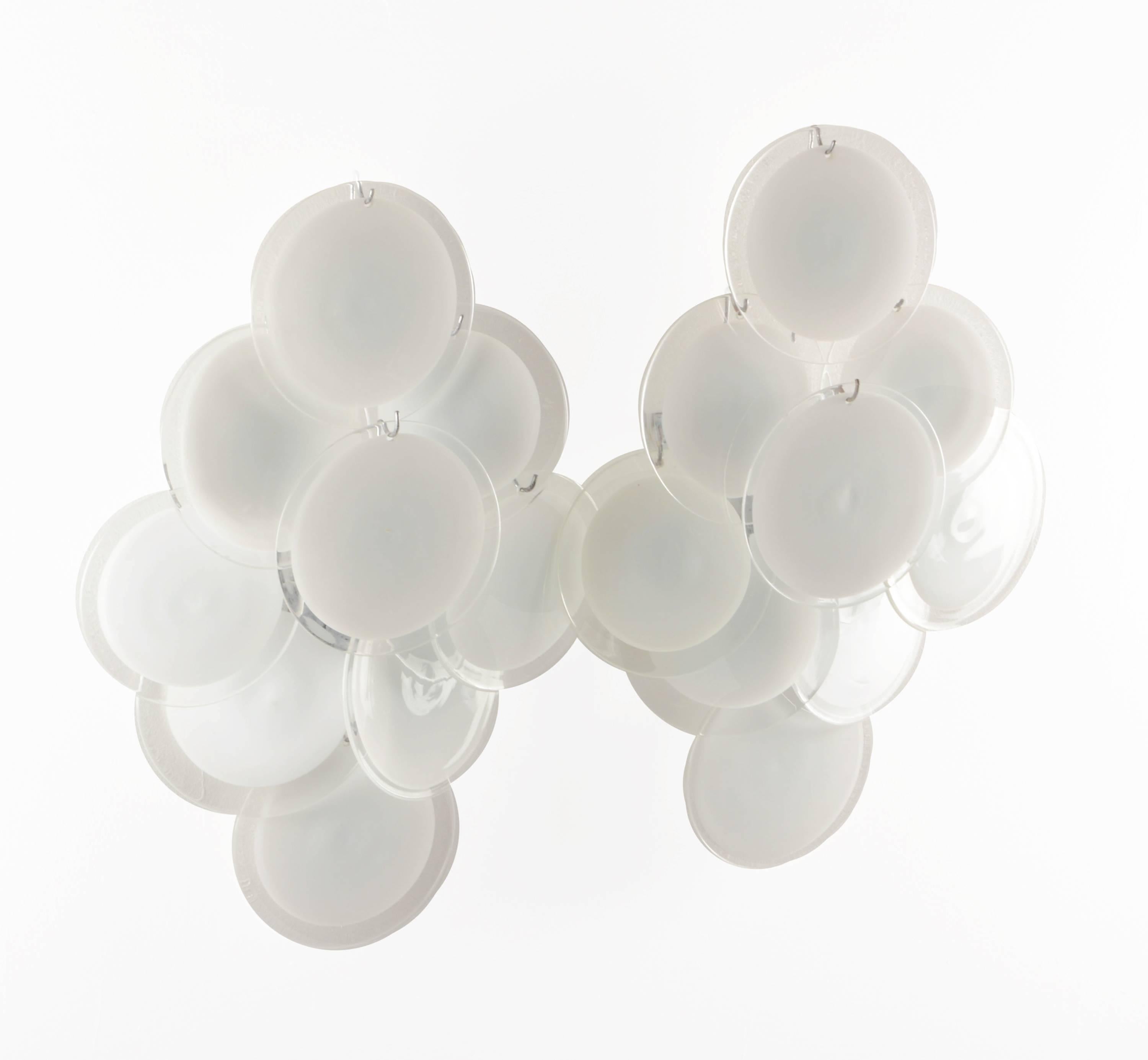 Pair of extra large wall lamps by Vistosi. Each sconce has nine pieces of glass discs of slightly various size and execution since they are handmade. The glass discs will display different ratio of white and clear glass. Excellent condition and