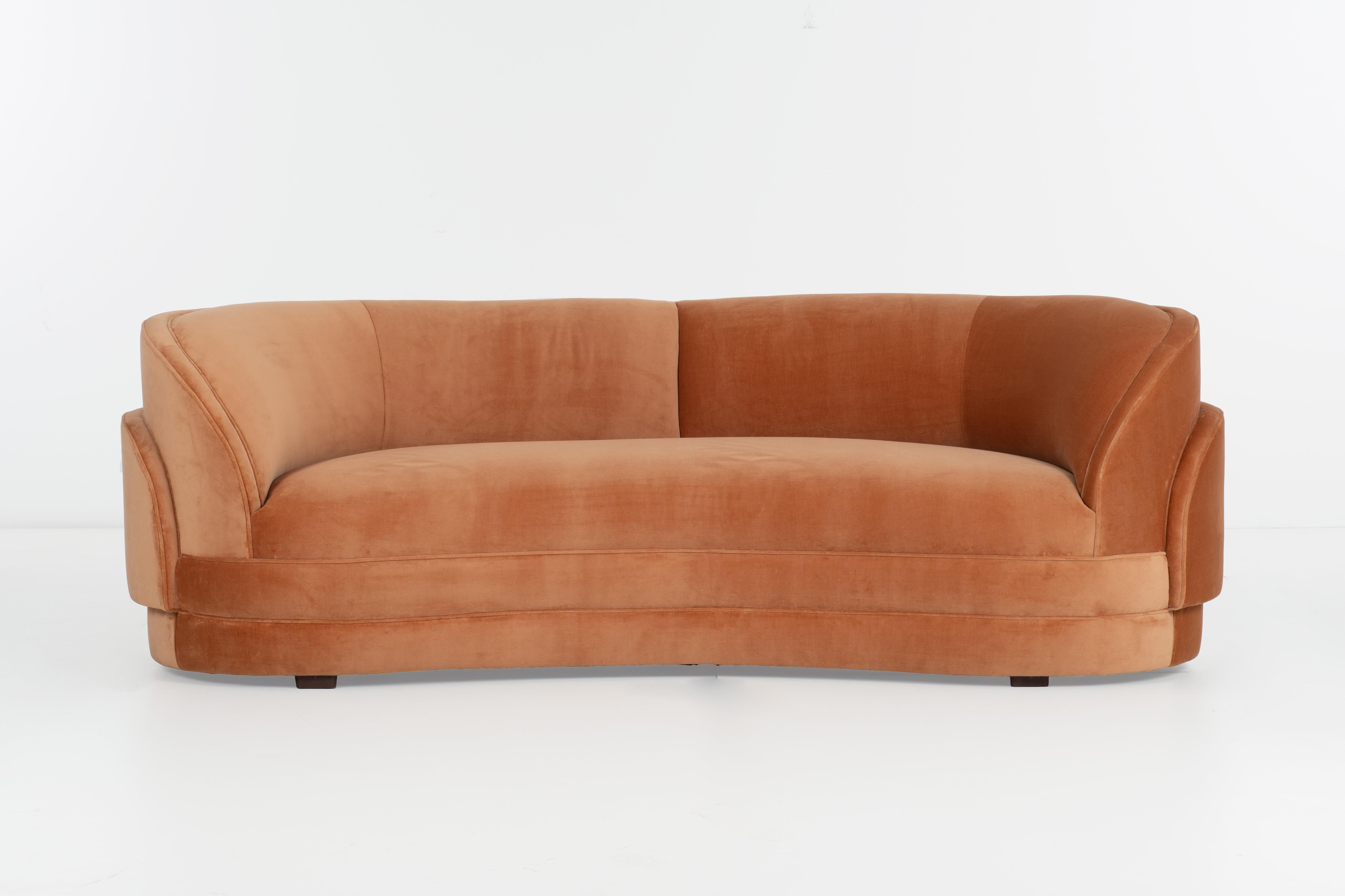 Pair of curved sofas with louvered backs. Upholstered with new foam in a peach colored cotton velvet.