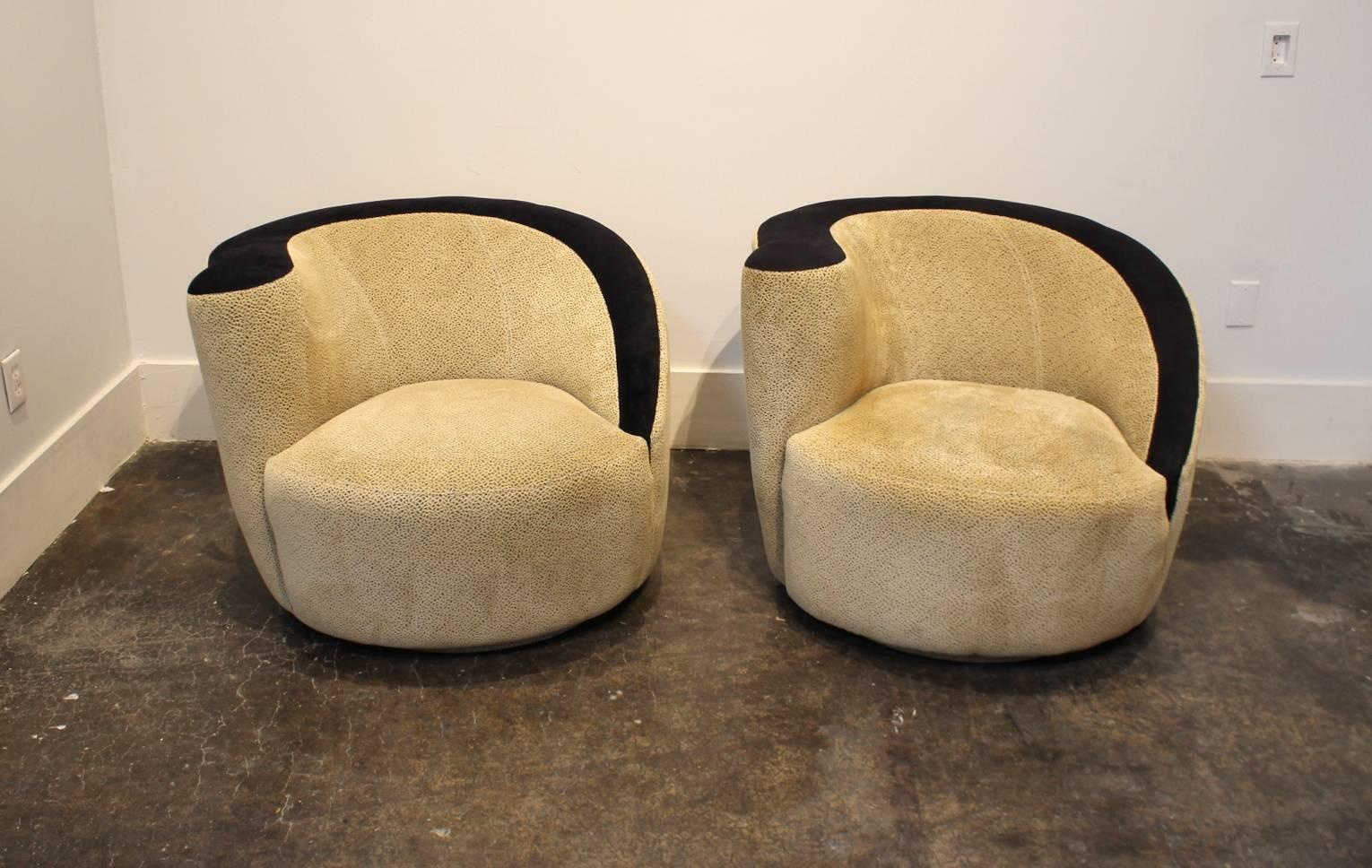 Set of two right-facing Kagan Nautilus swivel chairs. Light cream colored fabric textured with black specks topped by micro-suede like black accent along the top edge and arms. 

Condition: sturdy and clean. Light but large stain on one of the