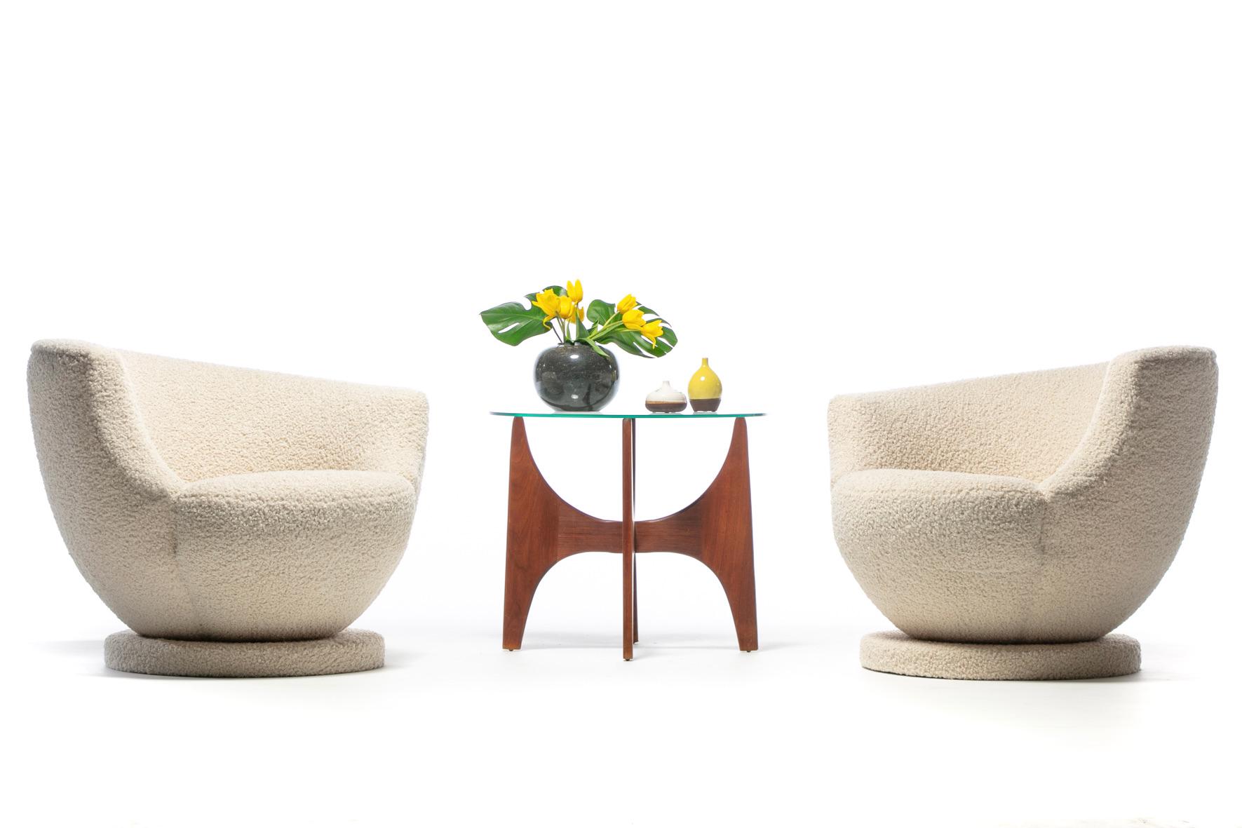 A less often found pair of Vladimir Kagan Modern swivel chairs newly upholstered in soft ivory bouclé fabric rated highly durable. Modern up and down and all around, the vibe is spaceship chic. Three quarter moon back arm support. Oval shaped bottom