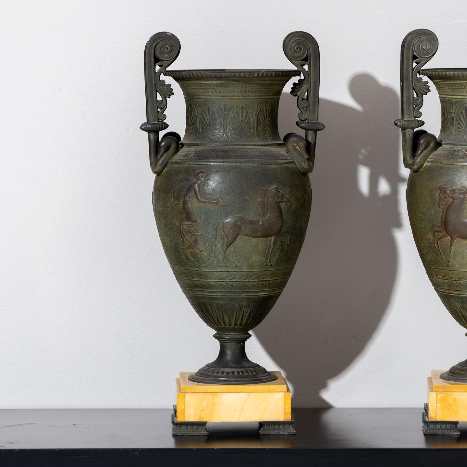 Paire de cratères à volute en bronze avec chars sur la paroi. Les vases reposent sur des socles carrés en marbre de Sienne (5,5 x 14 x 14 cm).