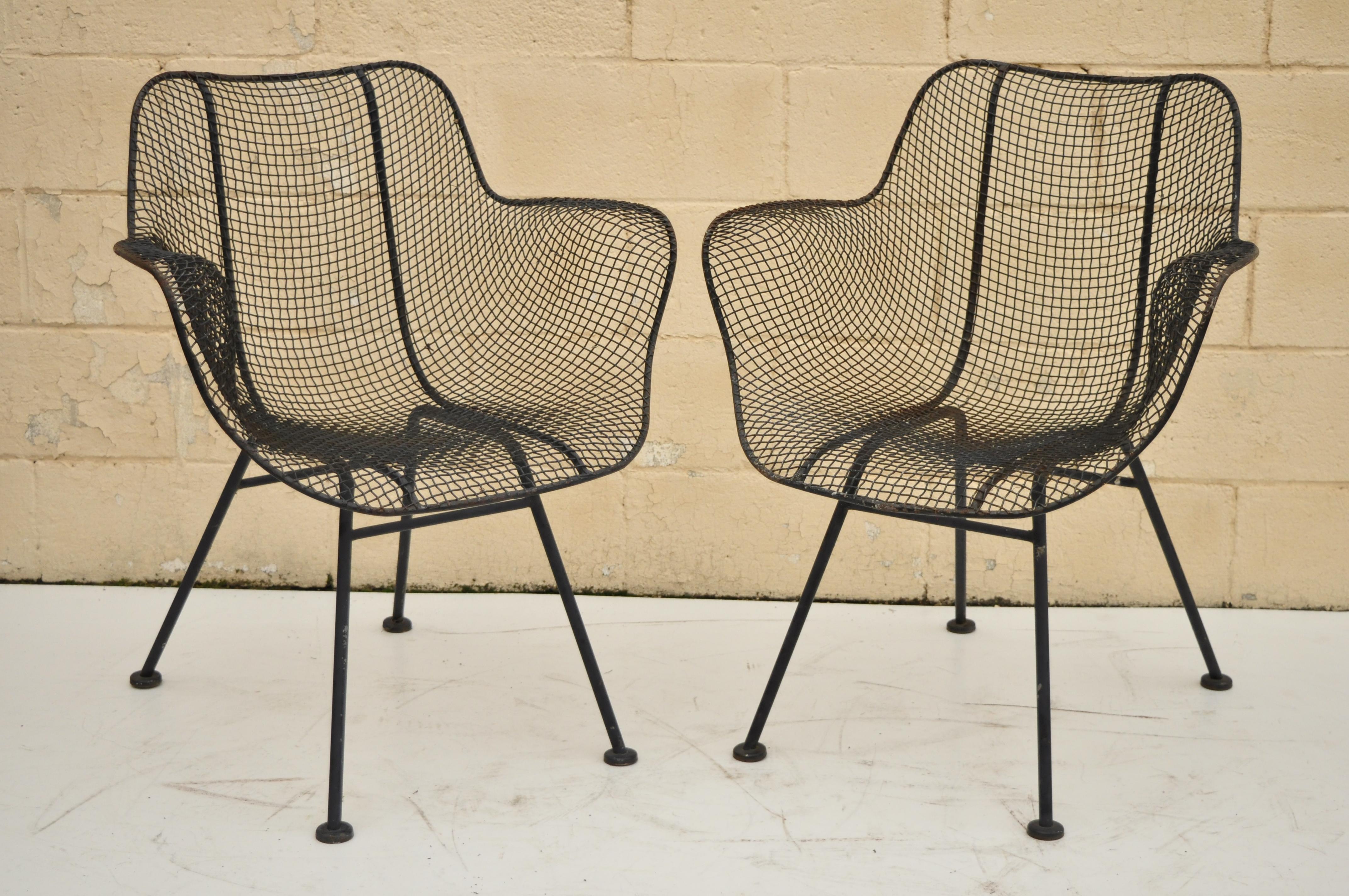 Pair of vintage Russell Woodard Sculptura metal mesh wrought iron dining side chairs. Items feature iron frame, metal mesh seats, iconic Mid-Century Modern design, very nice vintage item, circa 1950. Measurements: 32