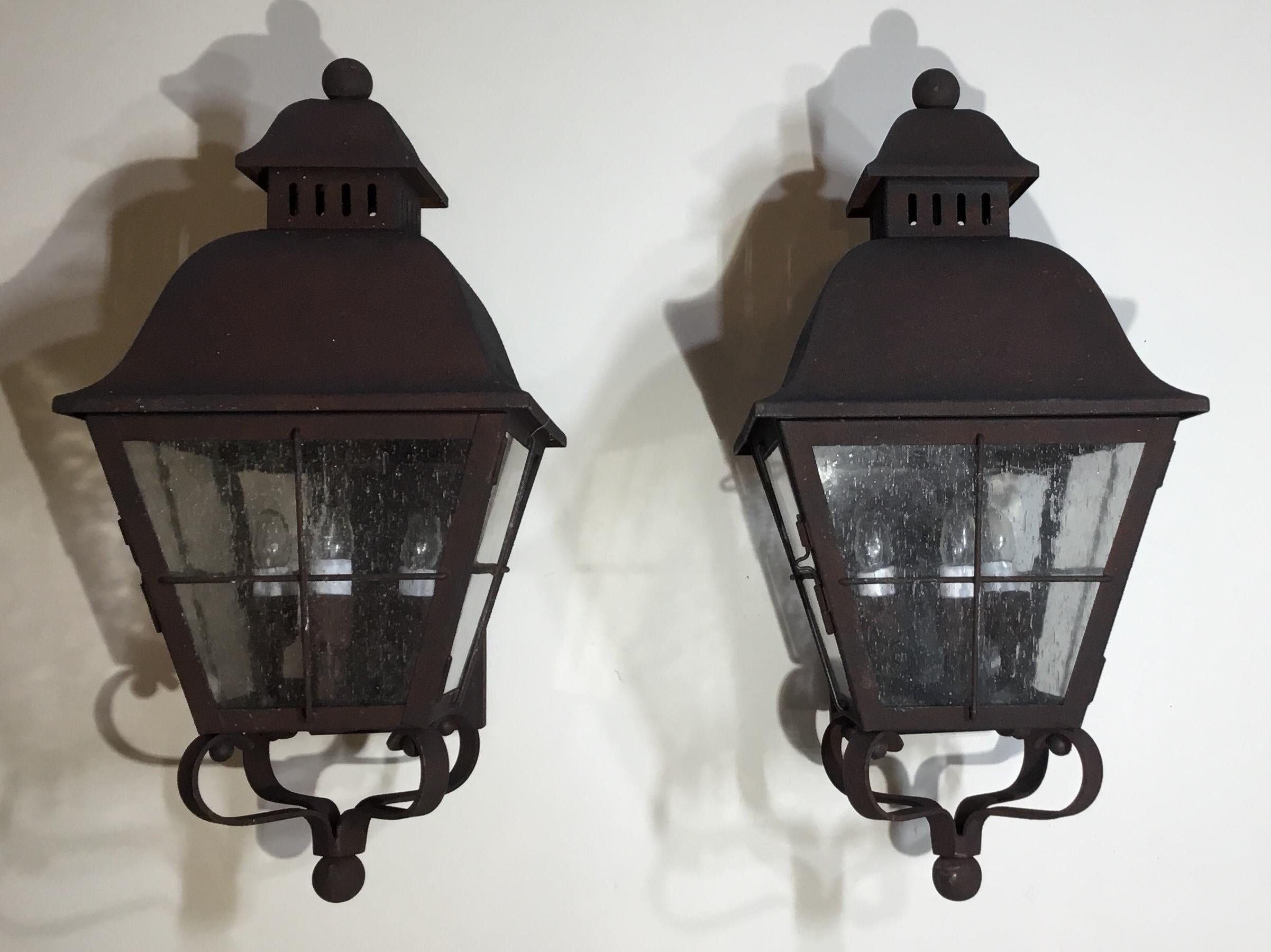 Elegant pair of wall hanging lantern ,hand forged from solid brass and have professionally rust finish applied, seeded glass, electrified with three 40/watt lights each, up to US code, UL approved. Great decorative pair of lantern for the front of