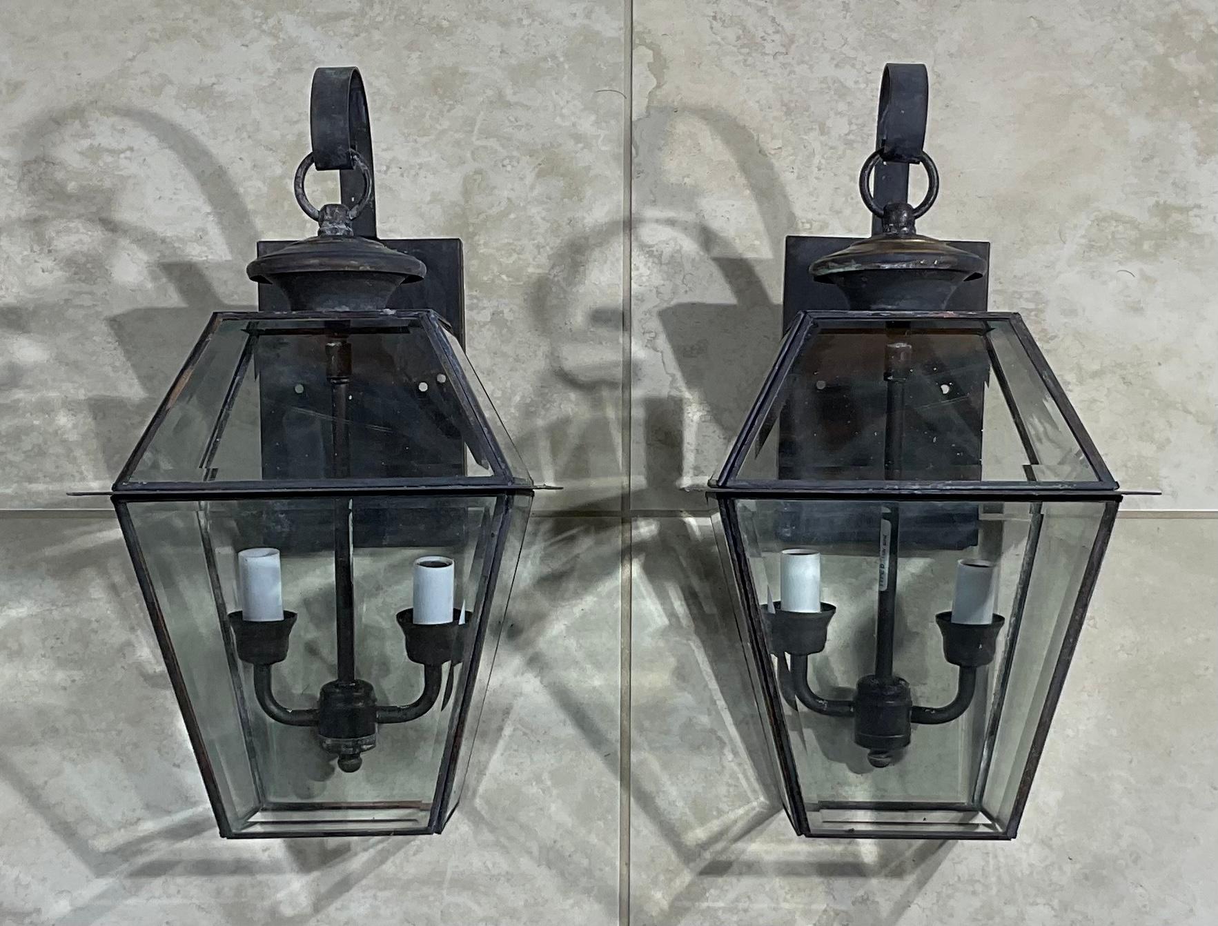 Elegant pair of wall lanterns made of brass, and thick decorative bevelled glass, electrified with brass cluster 0f two 60/watt lights each lantern. 
Suitable for wet location / or will be great looking light indoor as wall sconces.