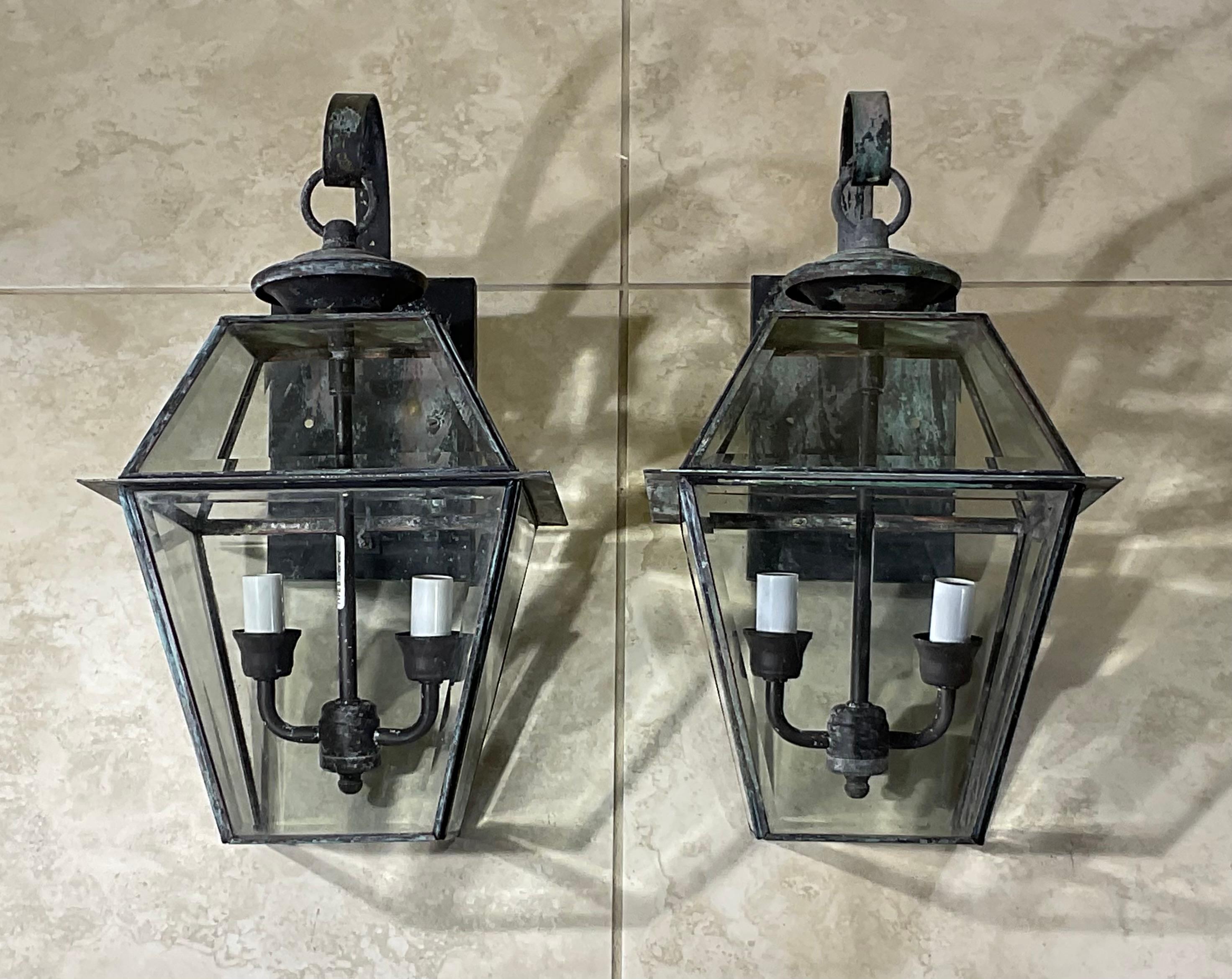 Elegant pair of wall lanterns made of brass, and thick decorative bevelled glass, electrified with brass cluster 0f two 60/watt lights each lantern. 
Suitable for wet location / or will be great looking light indoor as wall sconces.