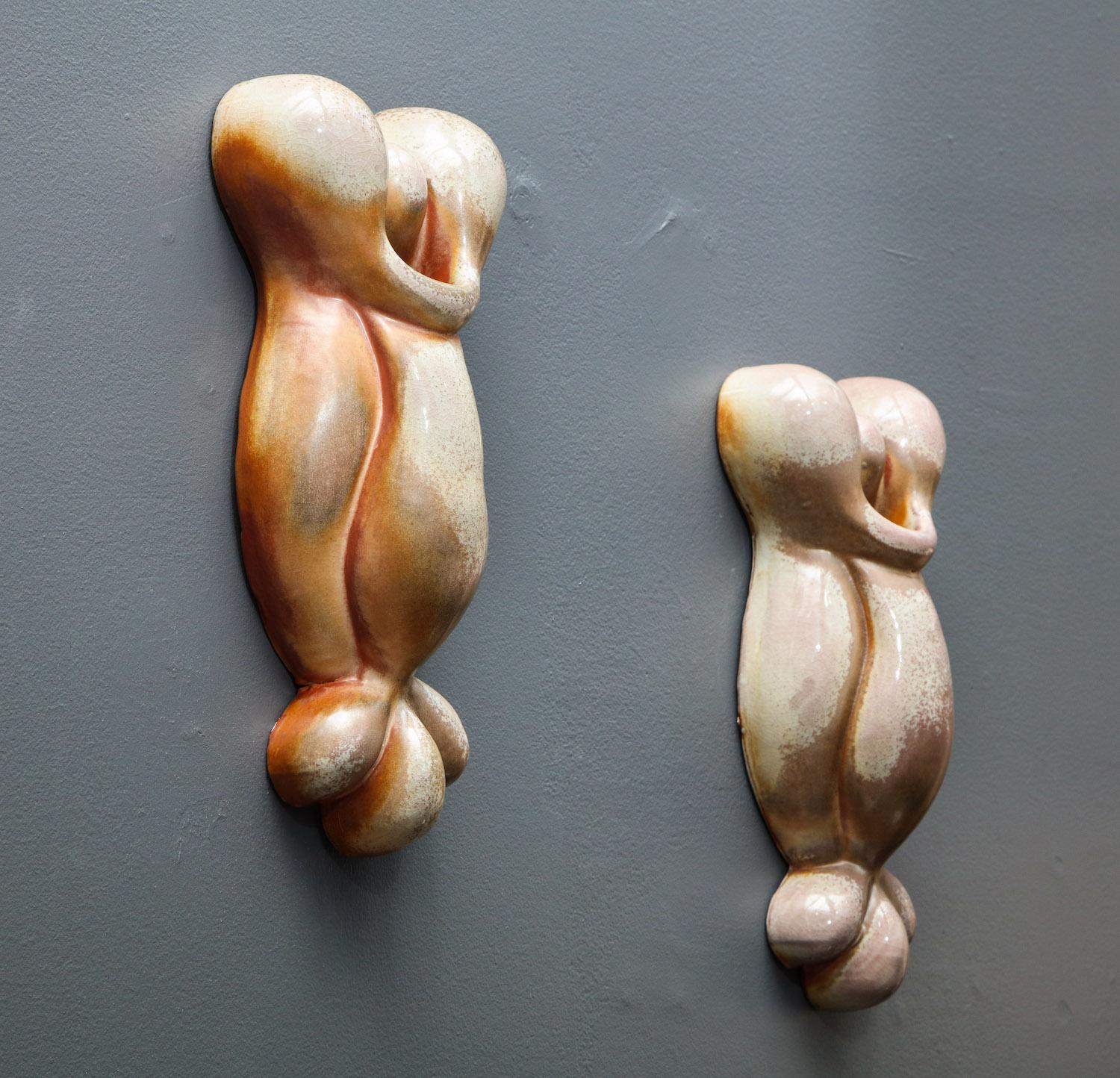 Pair of cast porcelain wall-mounted sculptures in warm and cool colored glaze. Wood fired. Artist-signed and dated on backside.