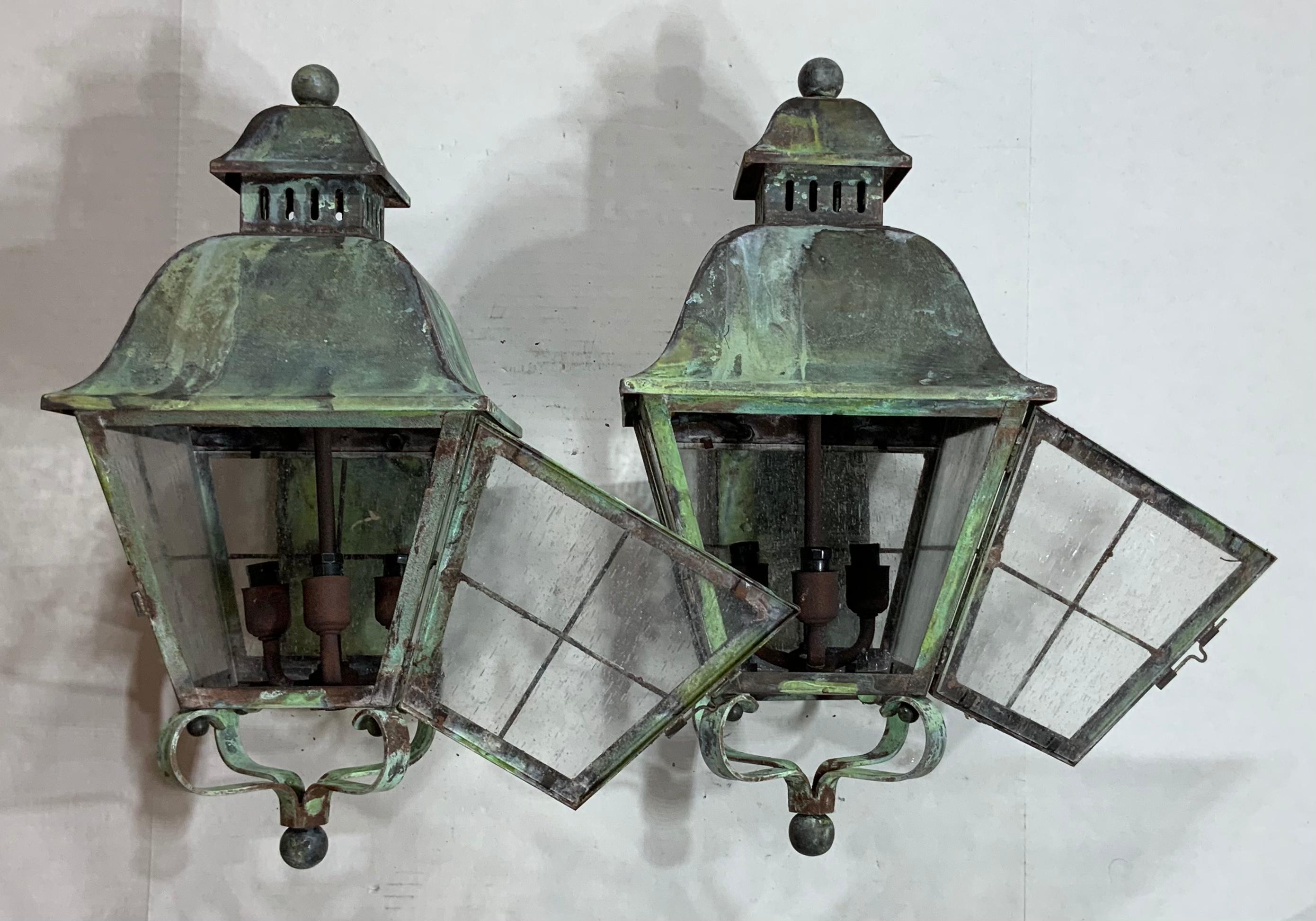 Elegant pair of wall hanging lantern, hand forged from solid brass, beautiful patina, seeded glass, electrified with three 40/watt lights each, up to US code, UL approved. Great decorative pair of lantern for the front of the house. Suitable for wet