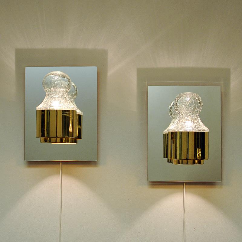 A very rare and special pair of wall lamps with a brass base and mirror back plate. Removable and rounded glass domes with enclosed air bubbles within the glass. These lamps model 7363 was designed by Kjell Munch for Høvik Lys, Norway and was a very