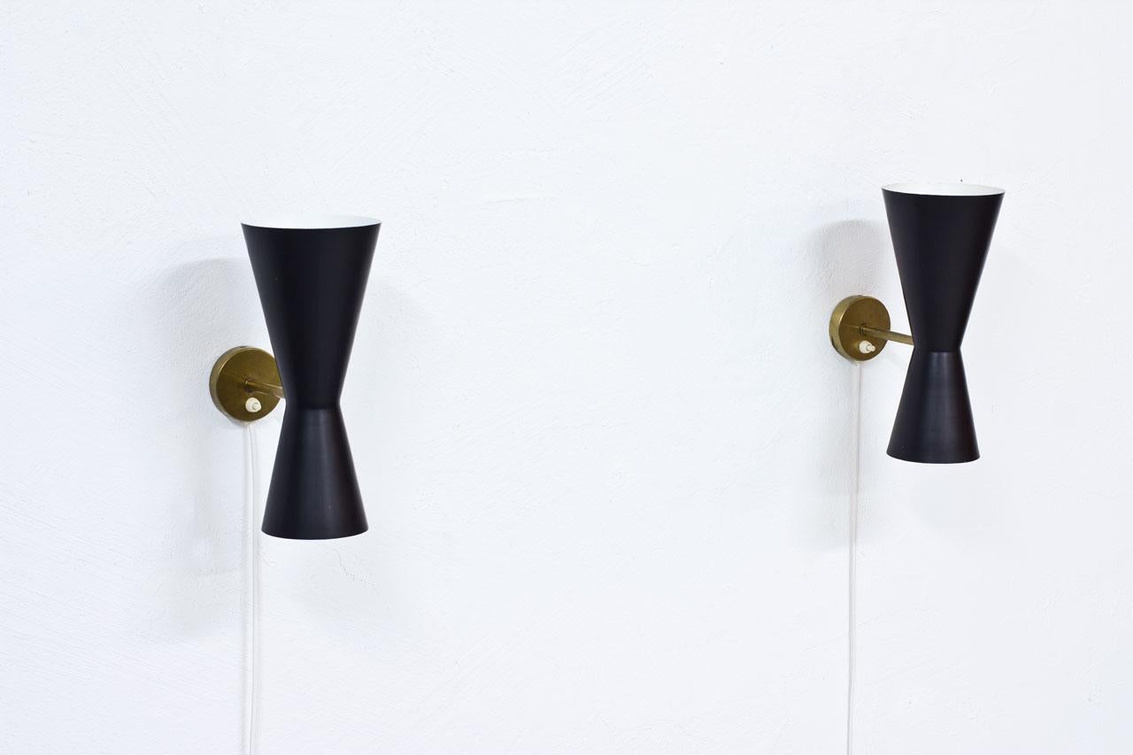 Pair of wall lamps designed by Alf Svensson.
Manufactured by Bergboms in Sweden during the 1950s.
Black lacquered metal reflectors with brass structure.
Good vintage condition with patina and minor signs of wear and age.