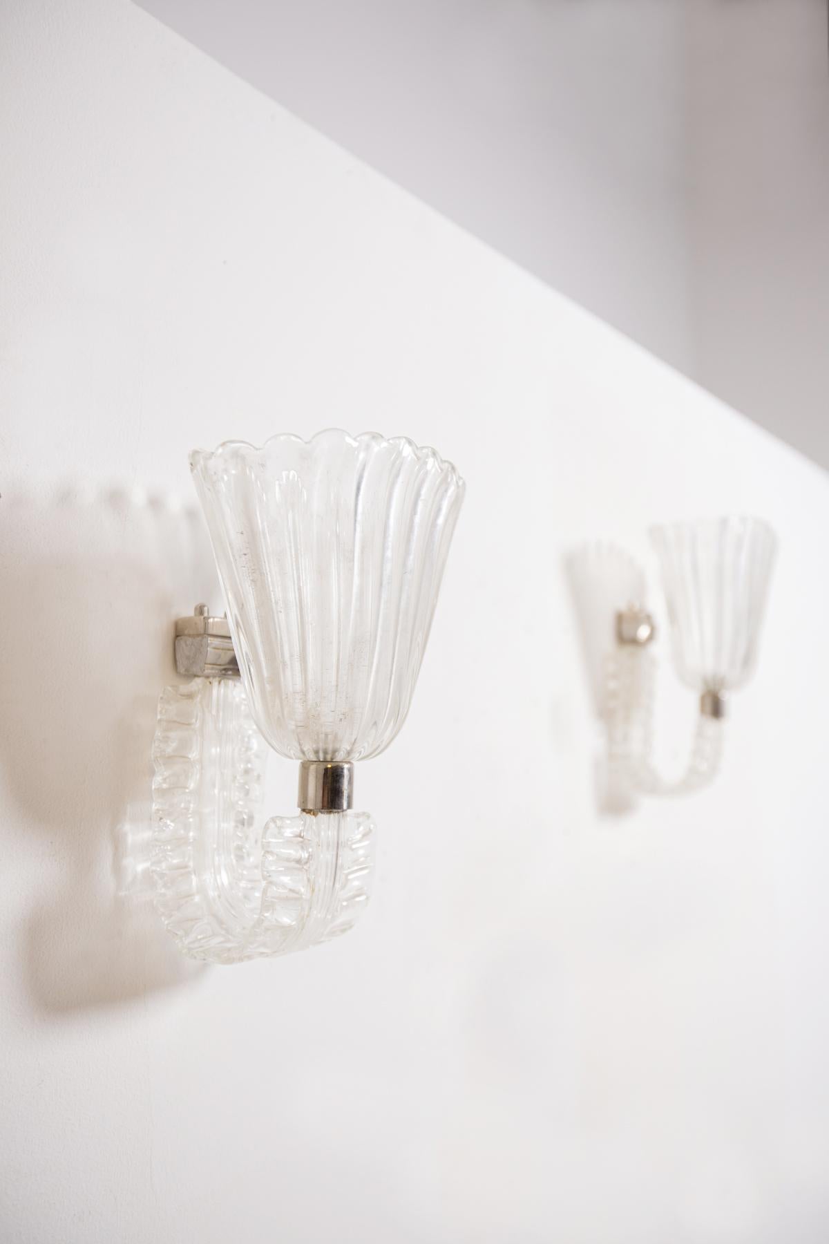 Elegant pair of wall lamps by Barovier & Toso in Murano glass. The pair of wall sconces are crafted in um beautiful flower shaped Murano glass. The particularity of the wall lamps have under its glass cup a curved glass in the shape of a leaf. The