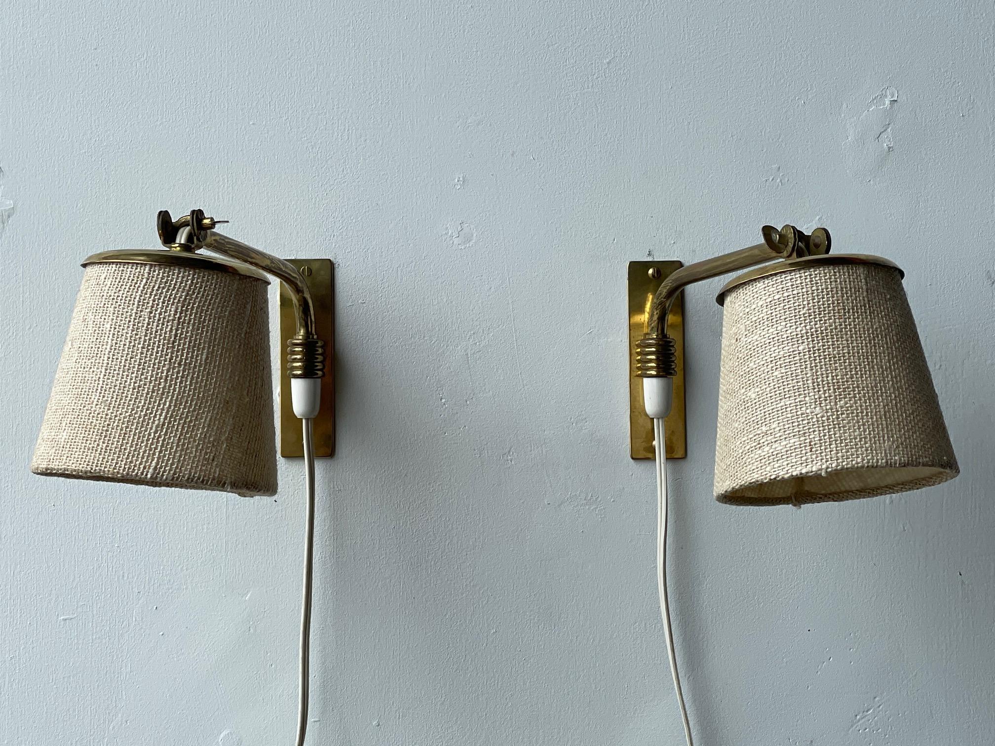 A pair of charming brass wall lights (sconces) by Itsu, Finland, ca' 1950's. Petite scale, wall switch, rewired for USA, can be used as uplights or downlights, pivoting. Nice original patina and beautiful attention to details, characteristic of