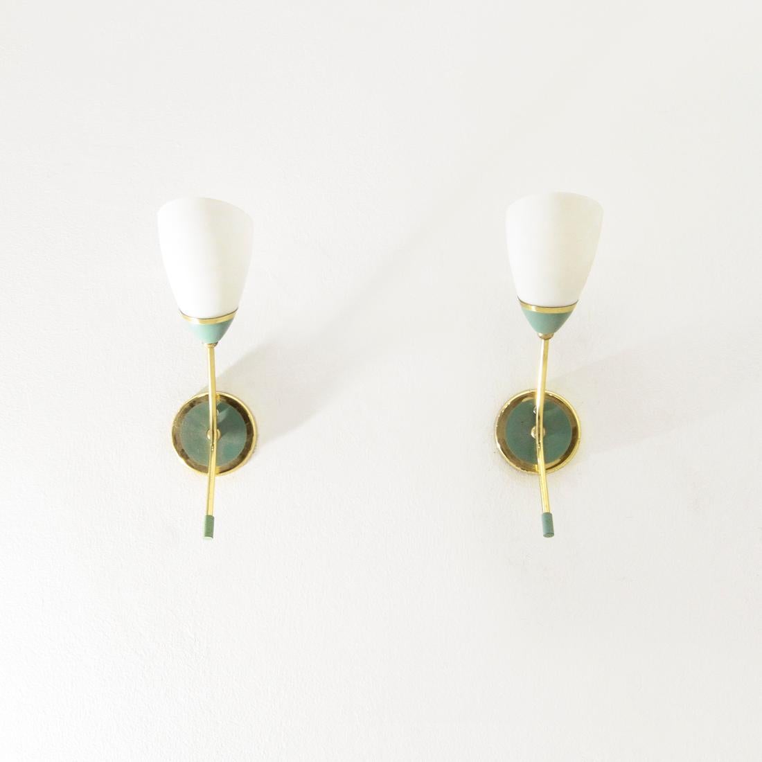 Pair of Italian-made wall lamps produced in the 1950s.
Brass and mint green painted metal structure.
Opal glass diffuser.
Good general condition, some signs of normal use over time over the paintwork.

Dimensions: Length 8 cm, depth 15 cm,
