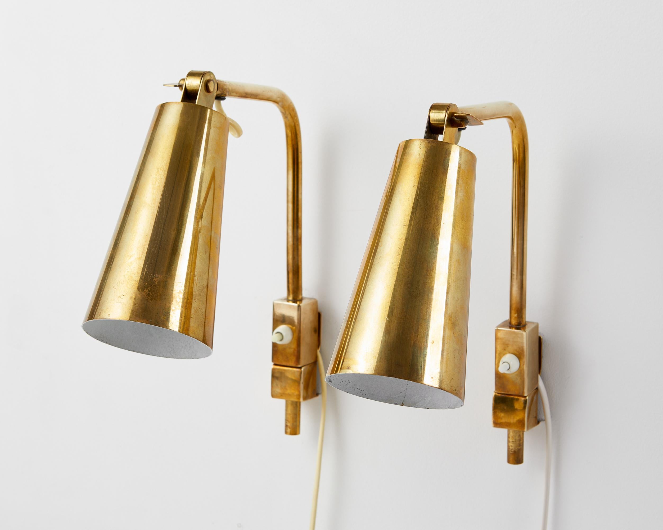 Pair of wall lamps model ‘9459’ designed by Paavo Tynell for Oy Taito,
Finland, 1960's.
Brass.

Engraved ‘OY TAITO AB’

The combination of cylindrical lampshades and square-shaped switch housings makes this elegant pair of Nordic wall lights