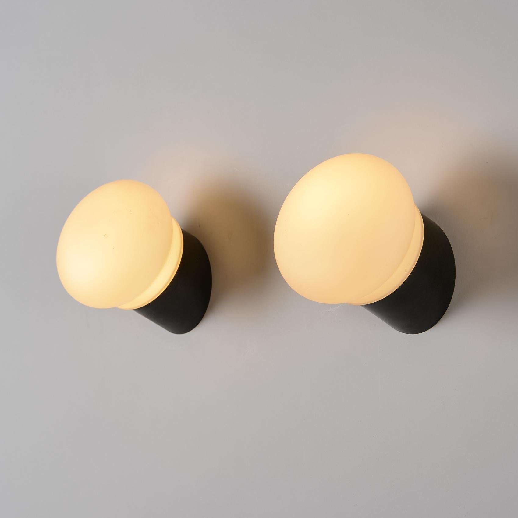 
Coppia di lampade da parete con struttura in plastica ABS nera e vetro opalino.

Modello selezionato da Charlotte PERRIAND per l'arredamento degli appartamenti della stazione sciistica di Les Arcs 1800.

Francia, circa 1970. 