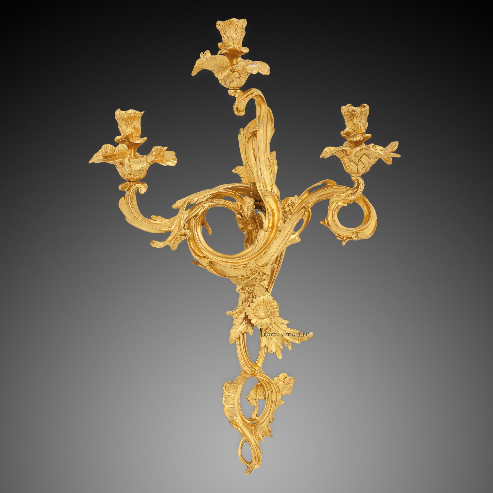 Rococo style sconces made of chiseled brass plated with 24 carats gold with flowers. 3 lights.