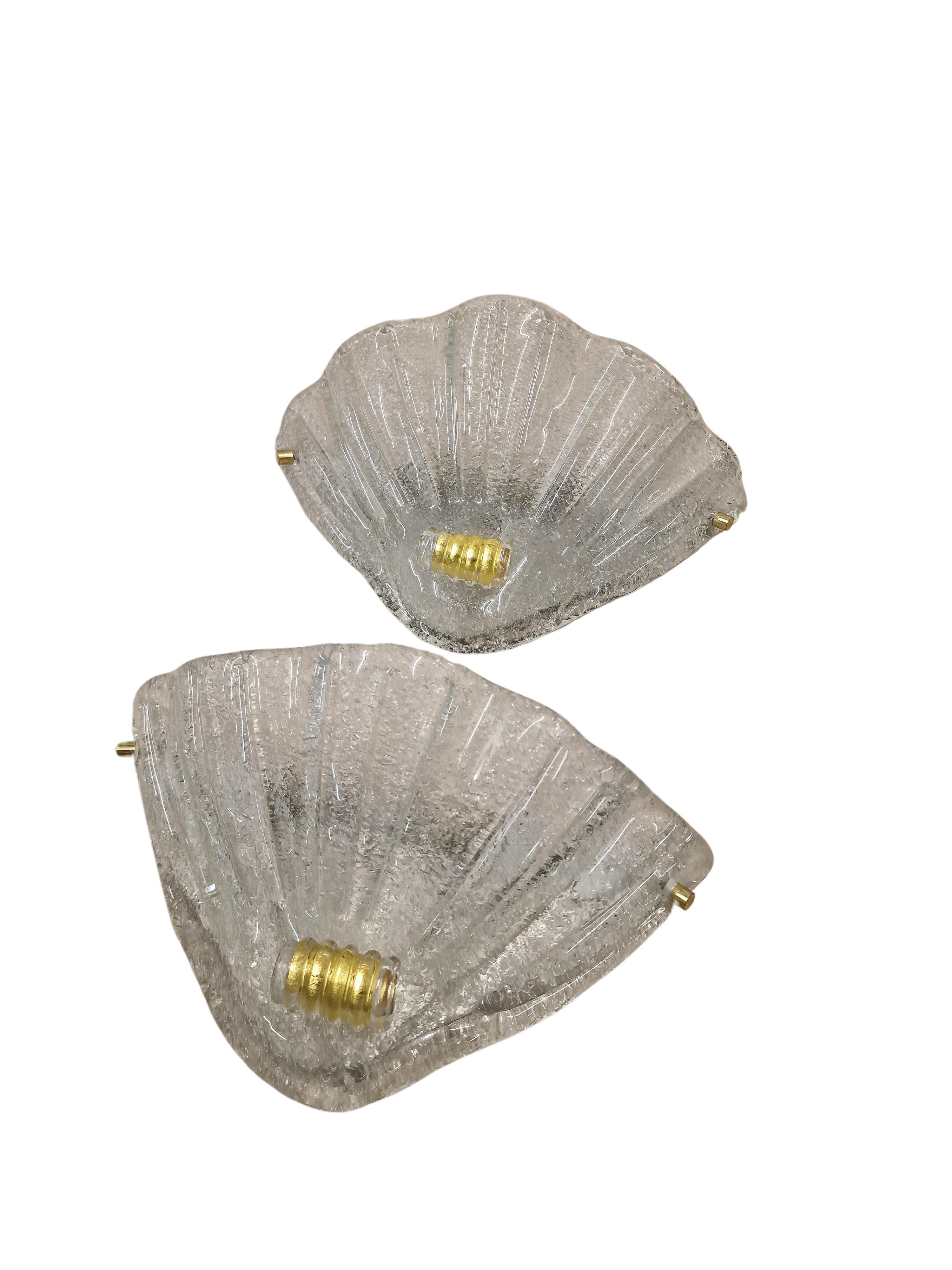 Charming wall lamps, appliques, made of glass - transparent and gold, made in the 1980s, handcrafted by a famous glass manufacturer from Murano, Italy.

The two lamps are in fantastic condition. The classic shape shows a sea shell that unfolds at