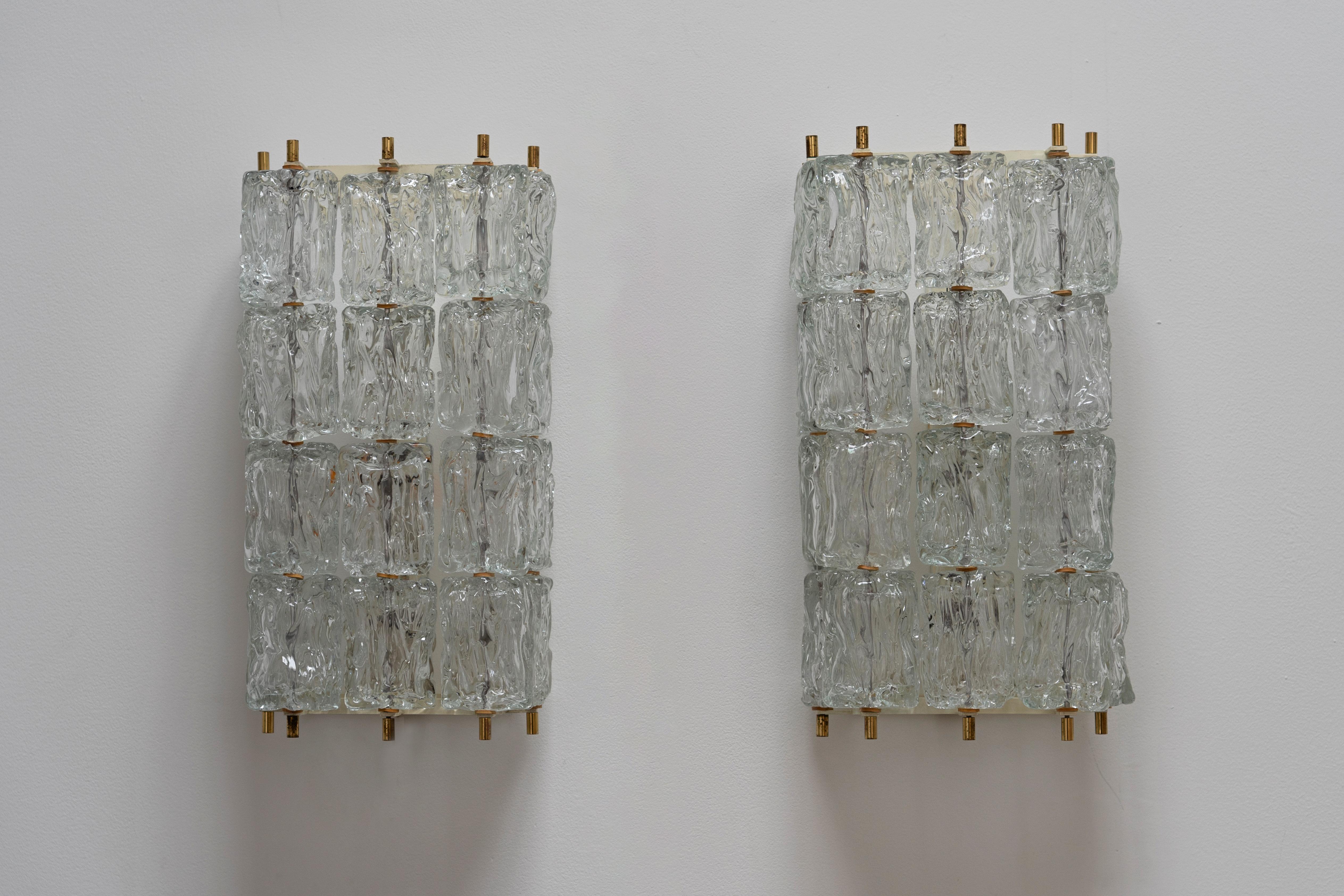 Diese einzigartigen Mid-Century-Wandleuchter vereinen Luxus und Stil auf höchstem Niveau. Sie bestehen aus 20 Einzelteilen aus handgefertigtem Murano-Eisglas und fangen den zeitlosen Charme des Hollywood-Regency-Stils mit einem Hauch von