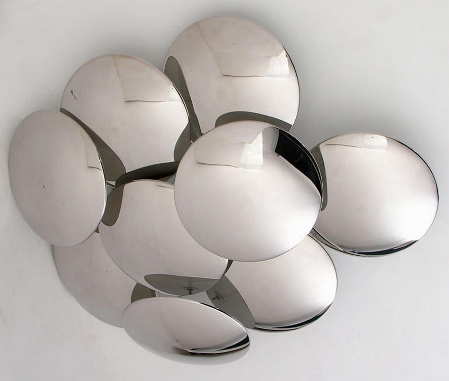 Pareja de apliques escultóricos, diseñados por Gioffredo Reggiani y fabricados por Reggiani, Vedano al Lambro, hacia 1965.
Son de acero inoxidable pulido y acero pintado, lacado en blanco en la parte posterior de las copas.
Este modelo es una obra