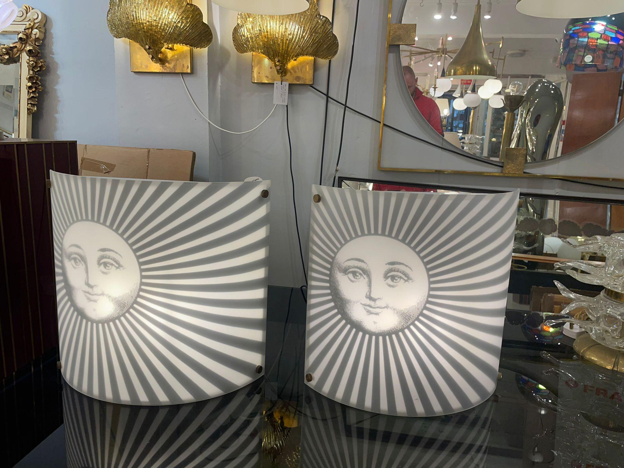 A beautiful pair of wall lights designed by Piero Fornasetti, depicting his muse Lina Cavalieri as a sun spreading bright rays of sunshine.