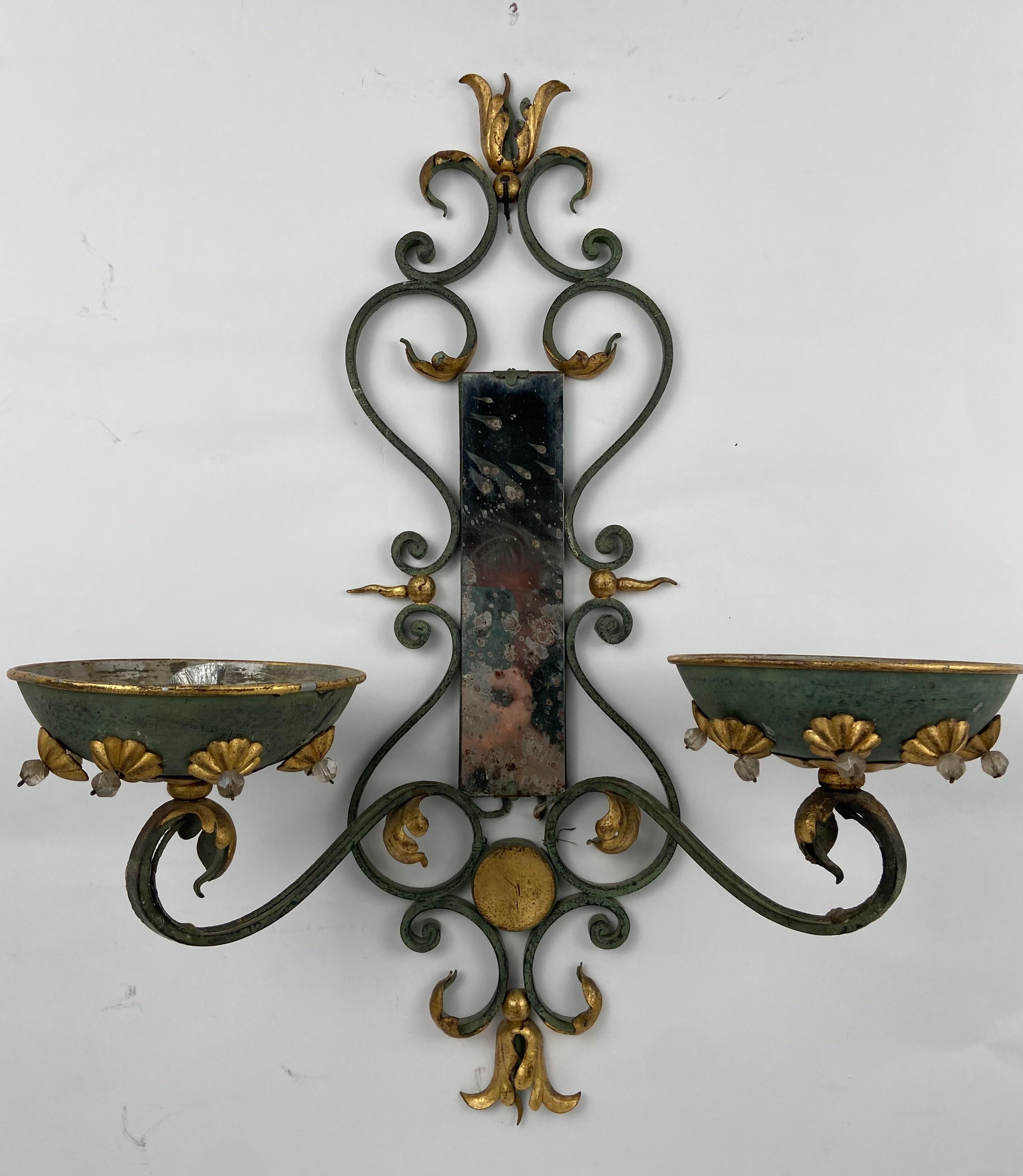 Pair of wall lights with a small mirror, in iron, patinated in green and gilded.
French, probably Paris, circa 1940.
