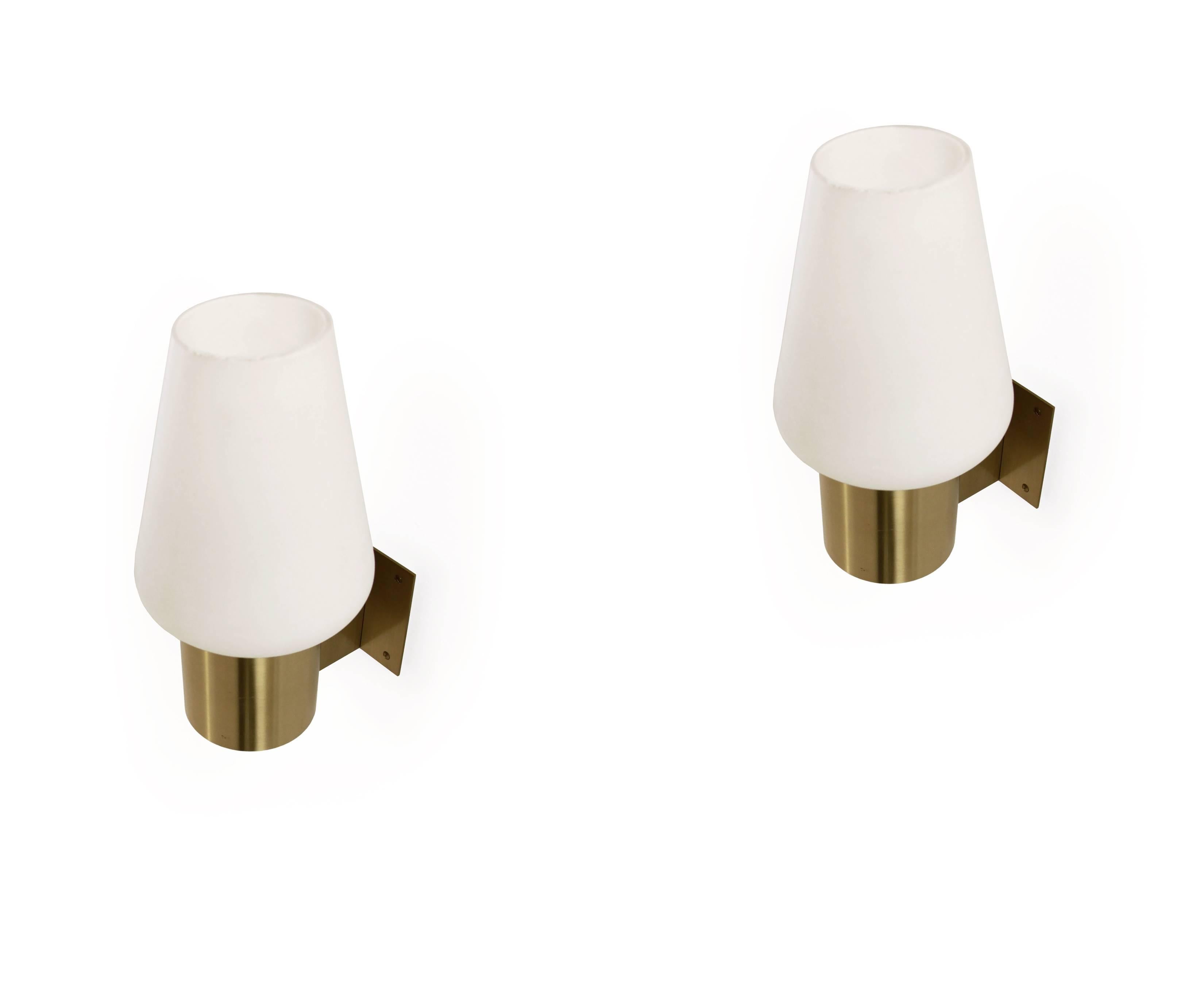 Classic and sublime pair of wall lamps in brass with shades in opaline glass. Designed and made in Denmark by Fog & Mørup from circa 1960s second half. Both lamps are fully working and in very good vintage condition.